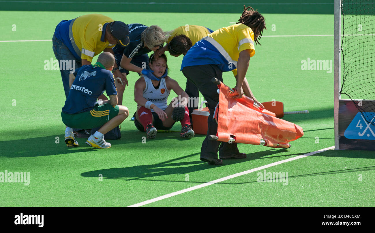 Lesioni sportive hockey femminile player sul terreno dopo essere stato colpito con una mazza da hockey Foto Stock