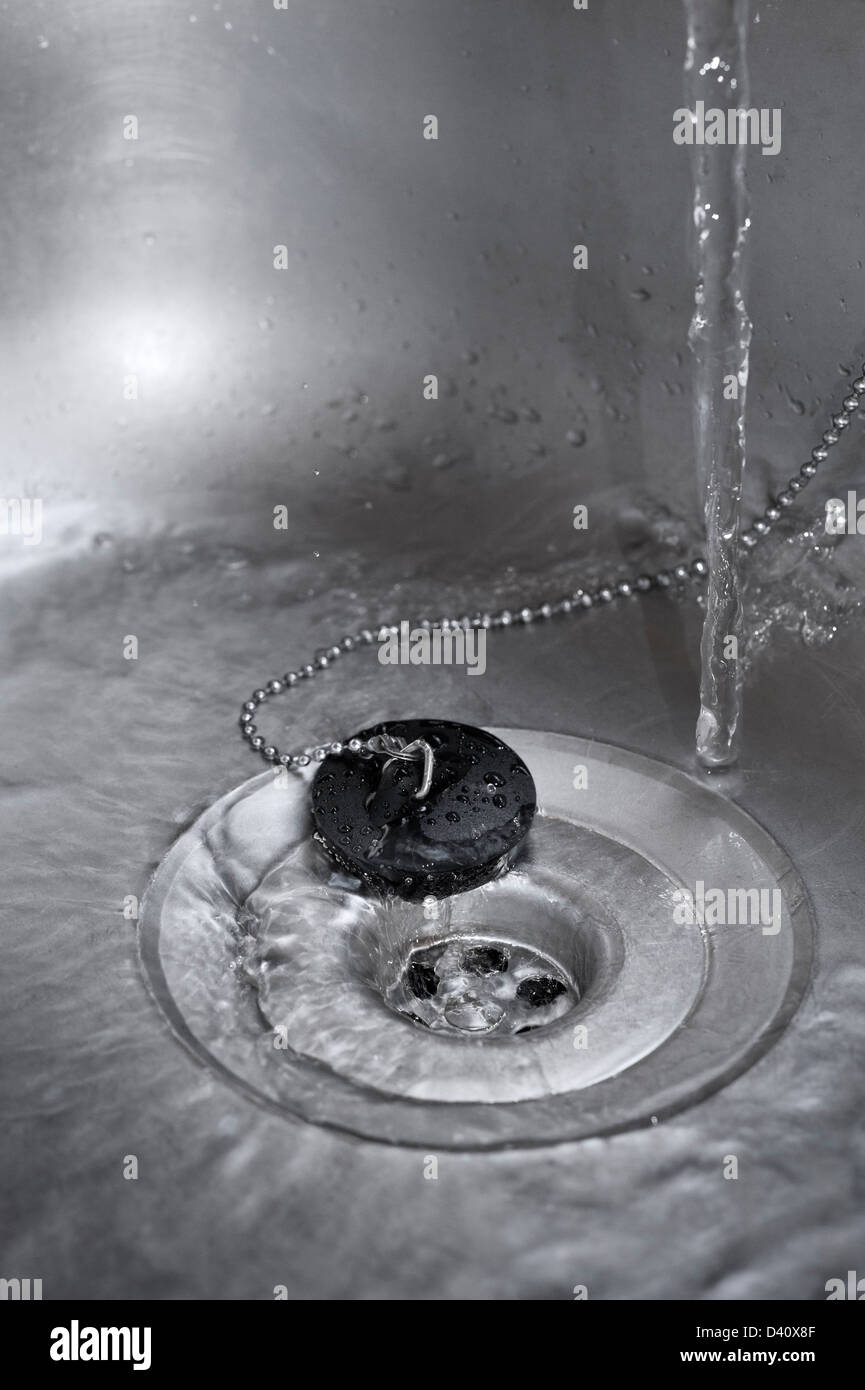 Lavello da cucina - acqua che scorre verso il basso la scarico in un lavello da cucina Foto Stock
