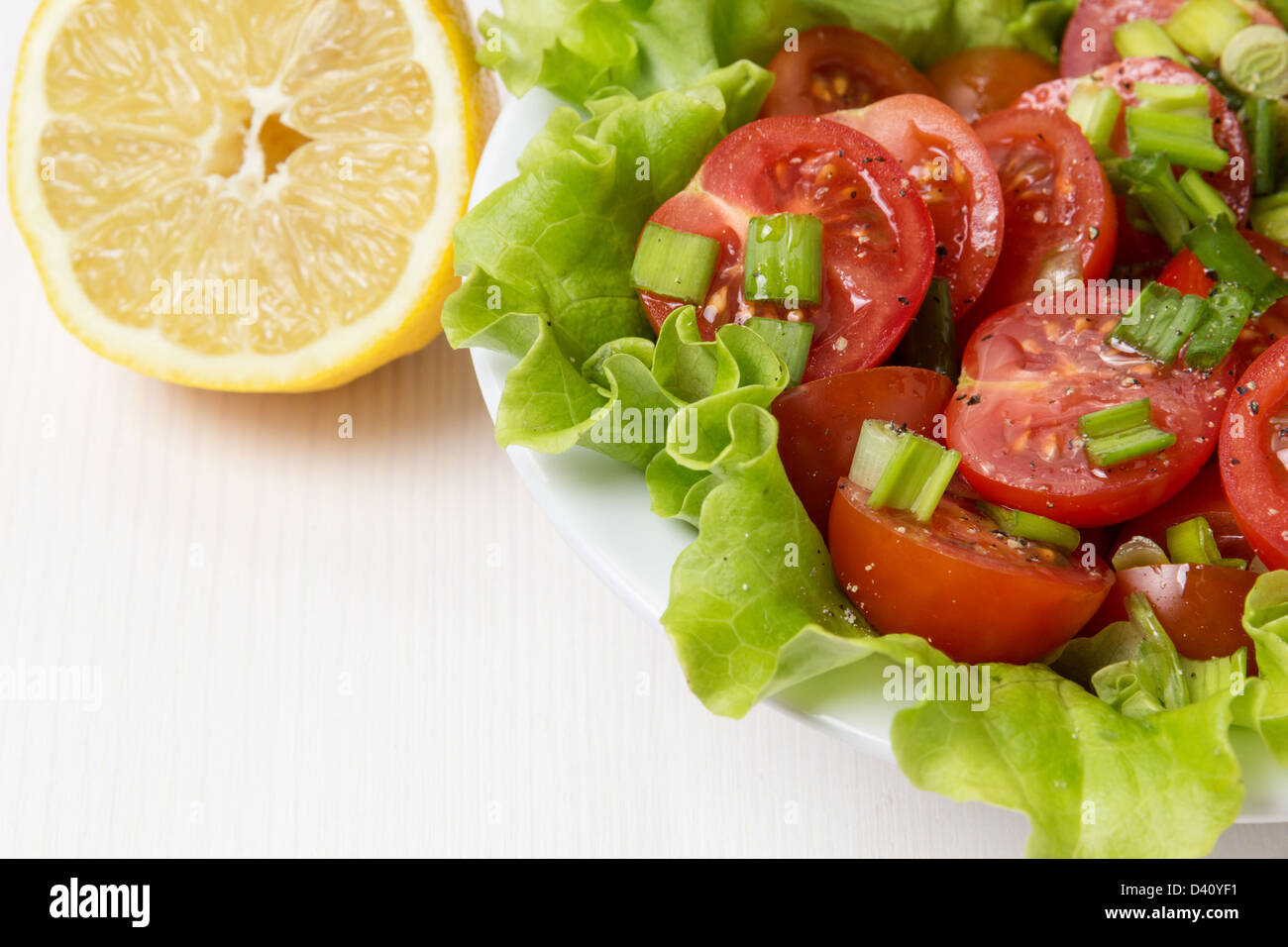 Luce fresca insalata con pomodorini e erba cipollina, bianco sul tavolo di legno Foto Stock