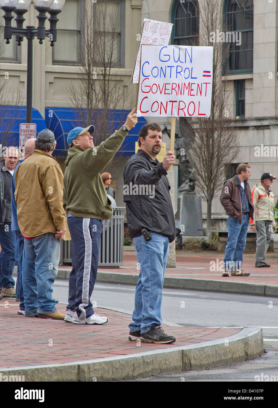 Gli uomini detengono il controllo dell'arma segni di protesta fino a macchine passando a una pistola anti rally di controllo in Asheville NC su 23 Febbraio, 2013 Foto Stock