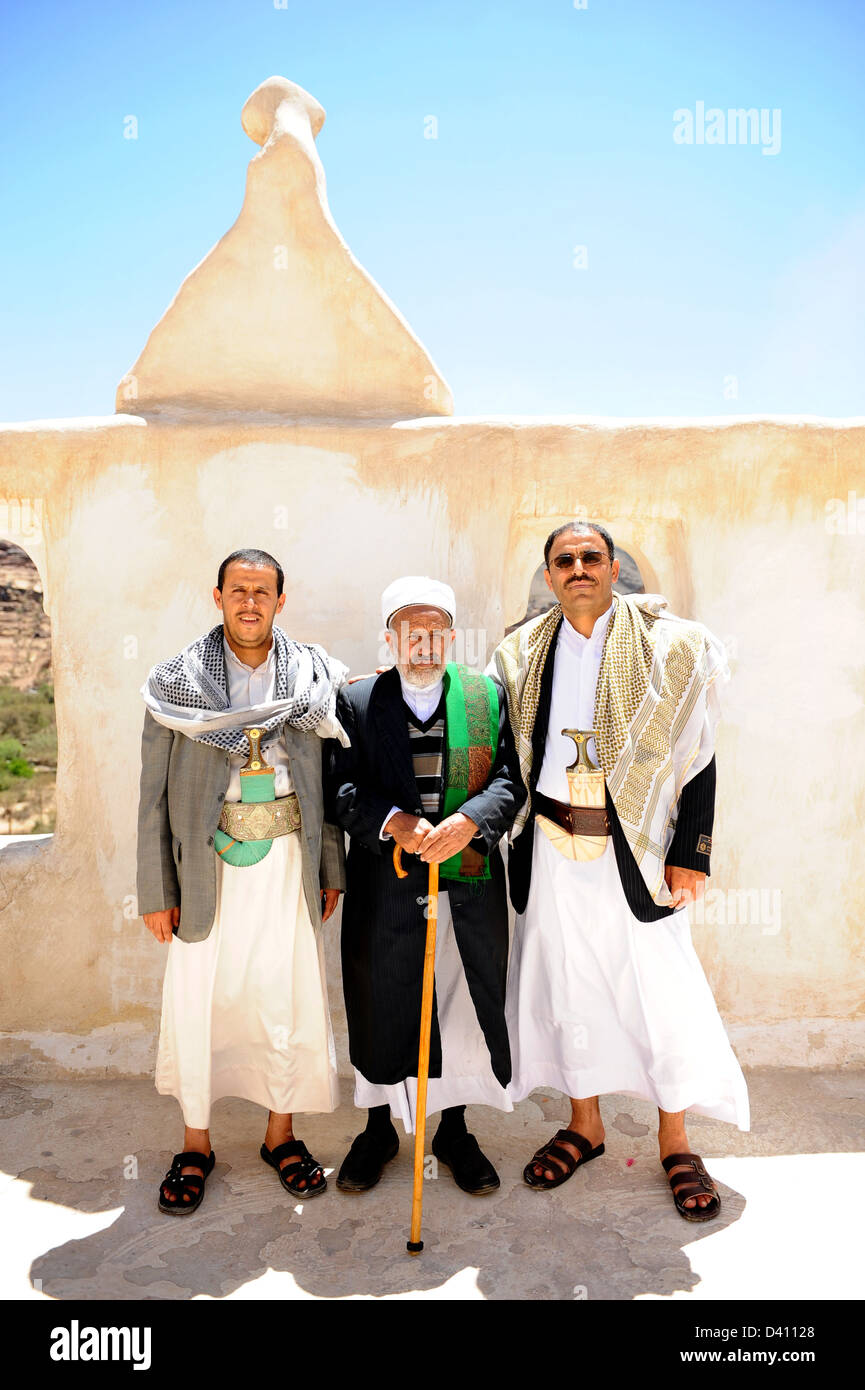 Padre e figli in abiti musulmani visitando 1930 Palazzo di Dar al-Hajar 15km al di fuori di Sana'a la città capitale dello Yemen Foto Stock