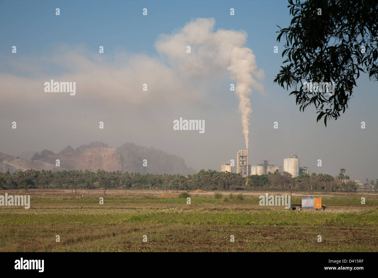 Campagna, campi in Birmania (Myanmar ), impianto industriale con fumo e inquinamento in background. Foto Stock