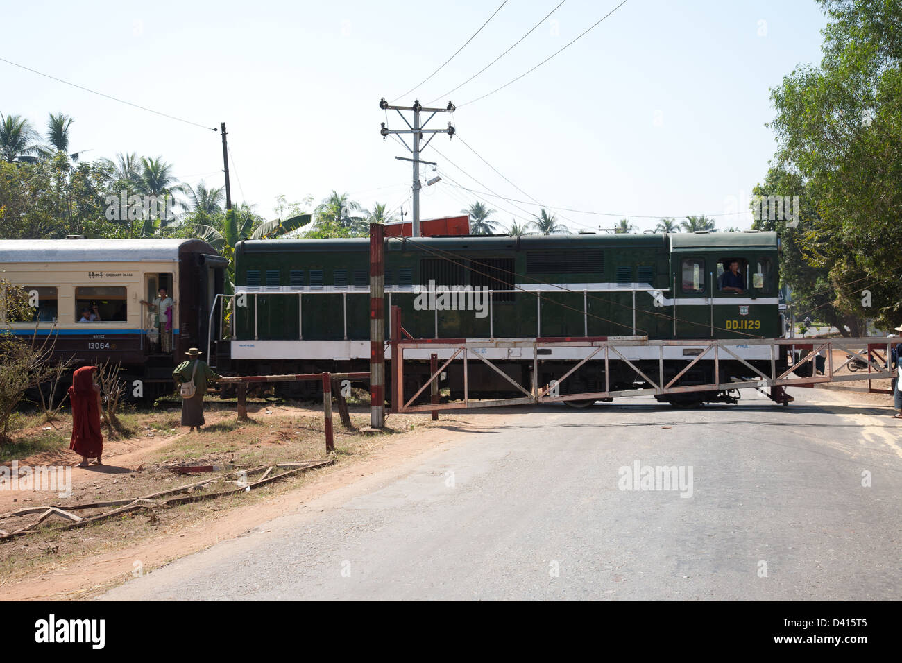 Il treno attraversa una strada in Birmania (Myanmar ) sul modo di Yangon. Foto Stock