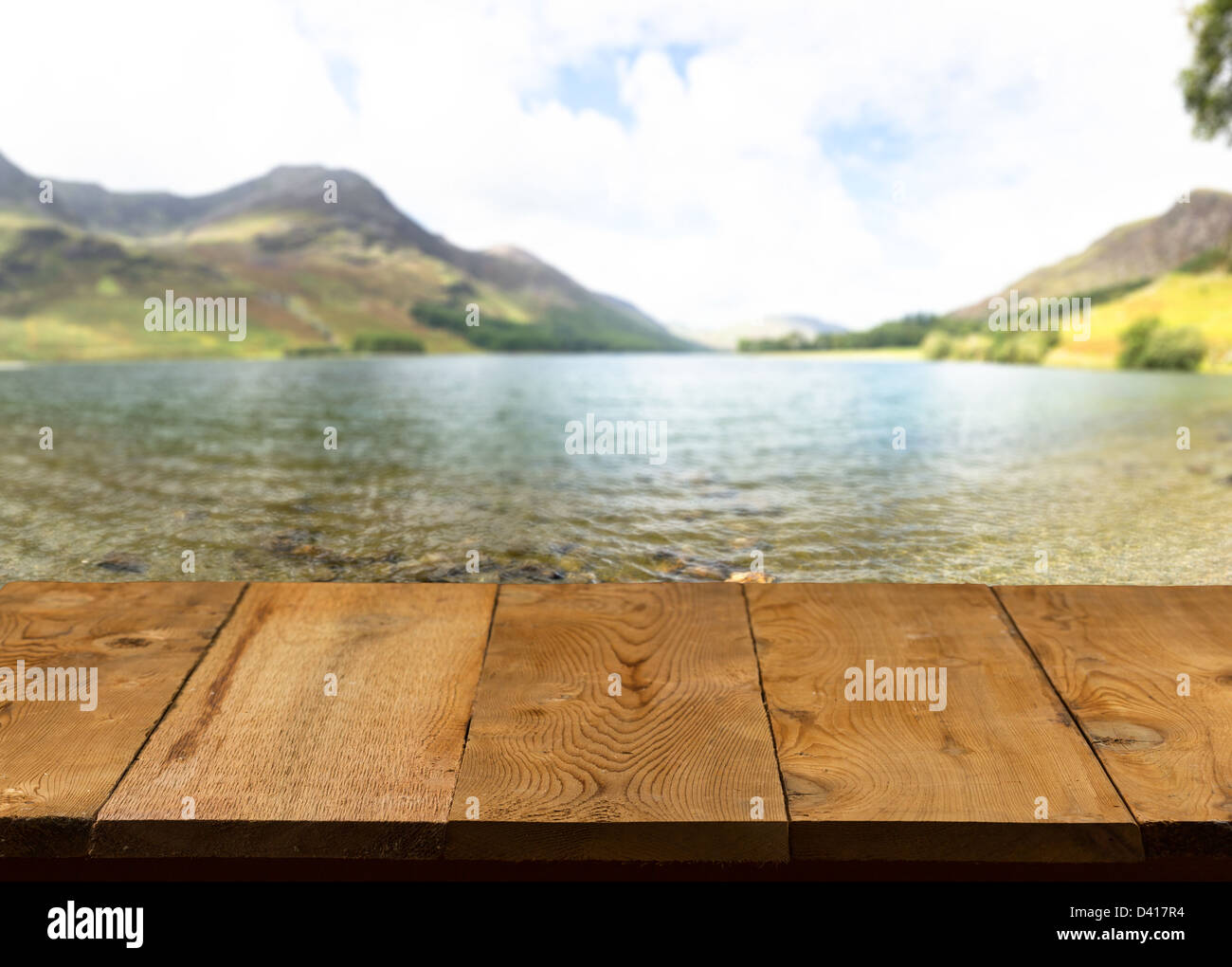 Il molo di legno o passerella o un vecchio tavolo in legno con immagine sfocata del Lake District in Inghilterra come sfondo Foto Stock