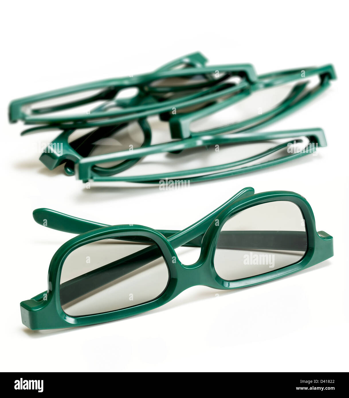 Coppia di verde 3d occhiali polarizzati per la visione di 3-d film per il cinema isolata contro bianco con pila di specifiche utilizzate in background Foto Stock