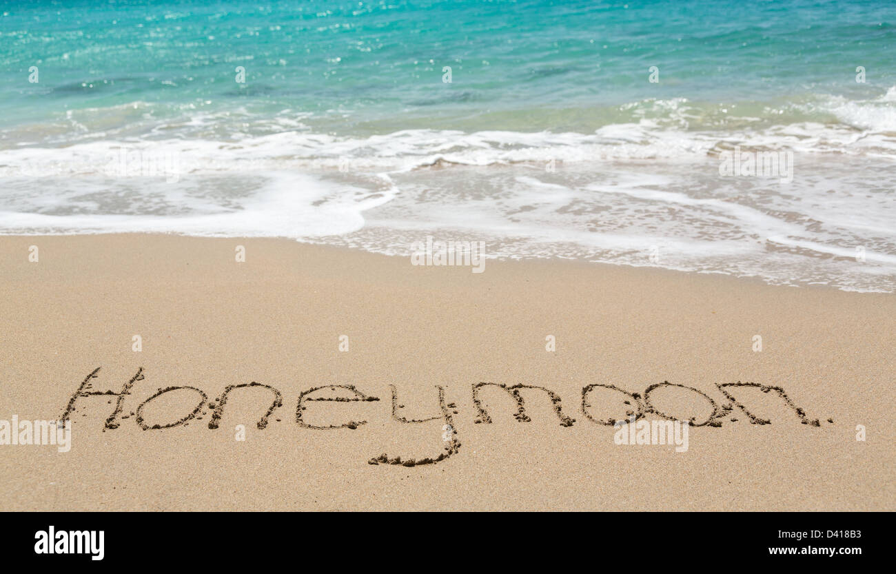 Luna di Miele parole scritte nella sabbia su una spiaggia tropicale Foto Stock