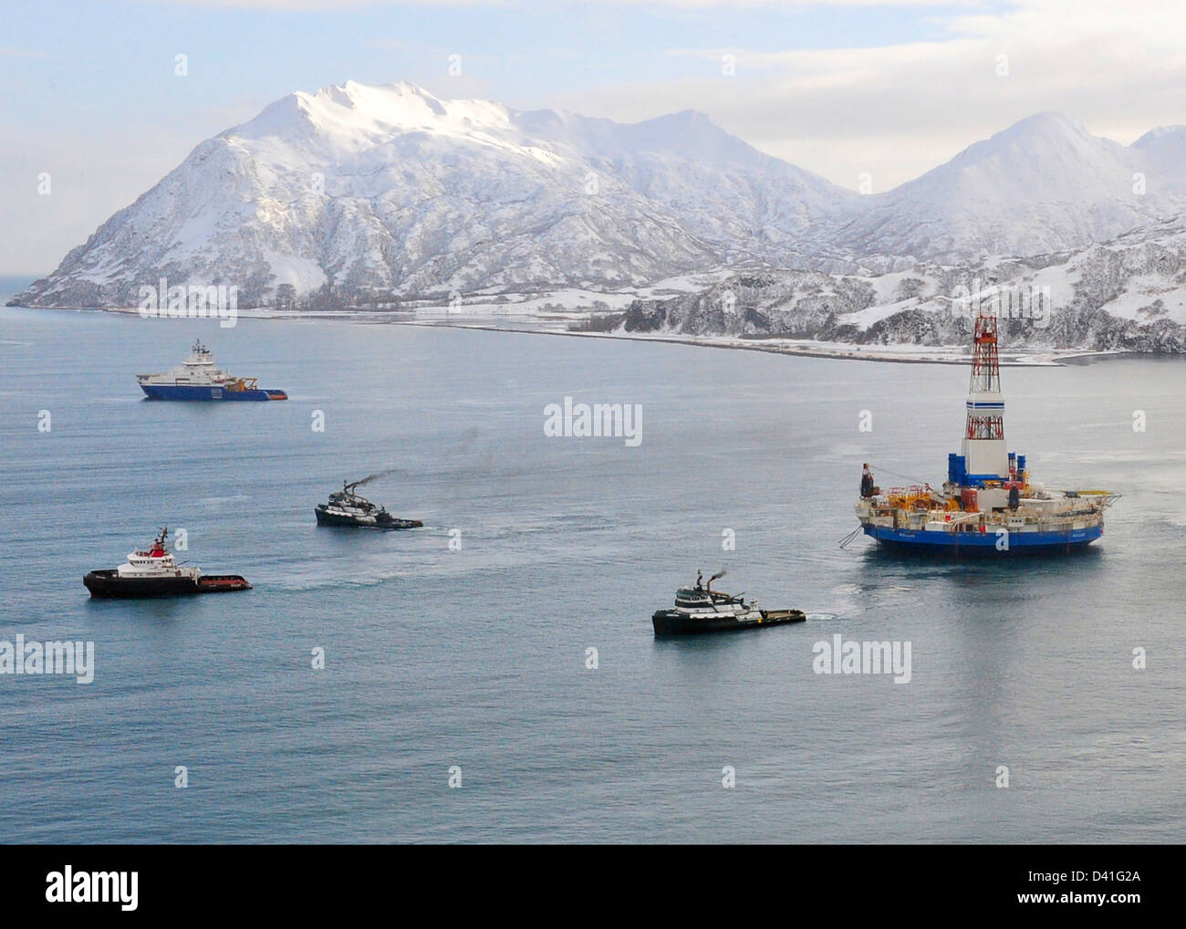 Barche rimorchiatore iniziare la matassa della parte conica di olio unità di foratura Kulluk Febbraio 26, 2013 da Kiliuda baia vicino all isola di Kodiak, Alaska. Il Kulluk si è arenata in una tempesta dopo la rottura della fune di rimorchio e ora è trainato per sicurezza. Foto Stock