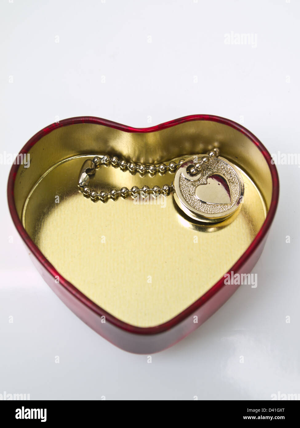 Un cuore metallico chiave a catena in acciaio inox con una scatola cuore isolato su bianco Foto Stock