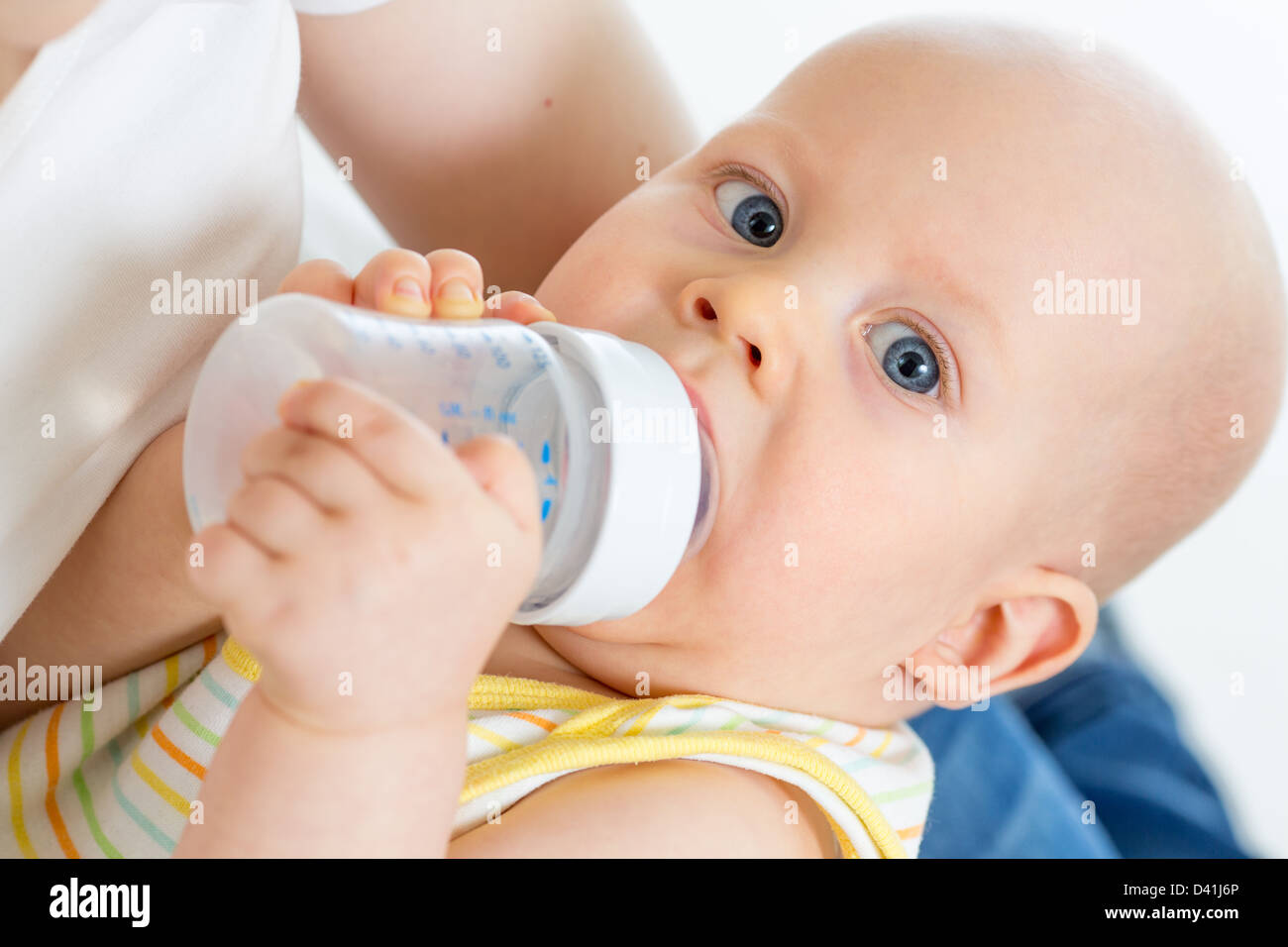Pretty baby boy bere latte o acqua da bottiglia Foto Stock