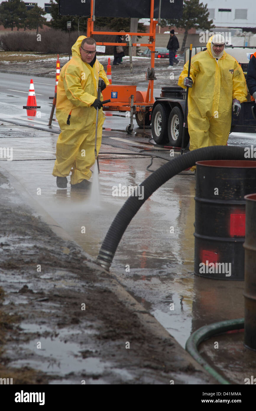 Warren, Michigan - Lavoratori pulire fino a pericolose fuoriuscite di materiale sulla spalla di una strada principale. Foto Stock
