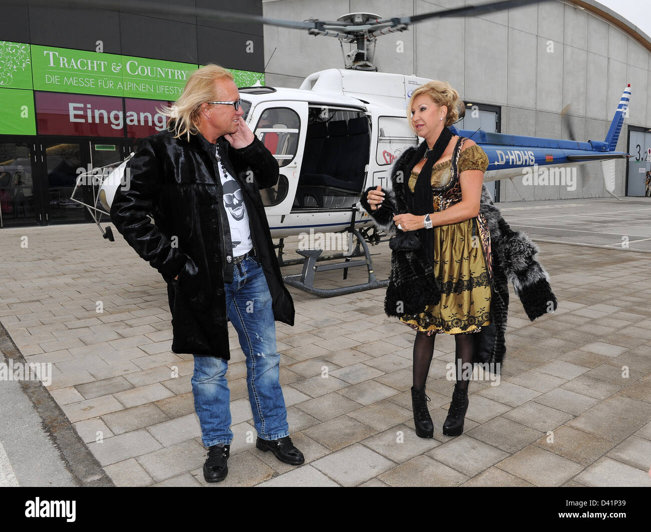 Carmen e Robert Geiss, noto dalla televisione docusoap 'l'Geissens', accanto ad un elicottero che li ha portati alla zona della fiera di Salisburgo, Germania, 01 marzo 2013. Carmen Geissen presenterà la sua nuova collezione 'C.G. Monaco' alla fiera "costumi tradizionali e del paese - Il Salone per un Lifetsyle alpina". Foto: Ursula Dueren Foto Stock