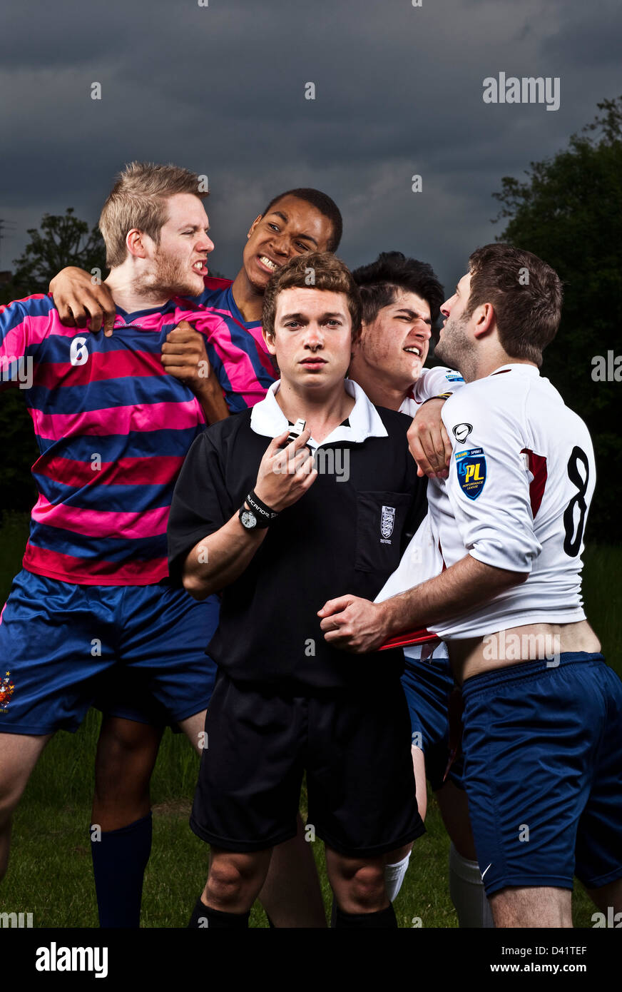 Arbitro arrabbiato con i giocatori di calcio Foto Stock