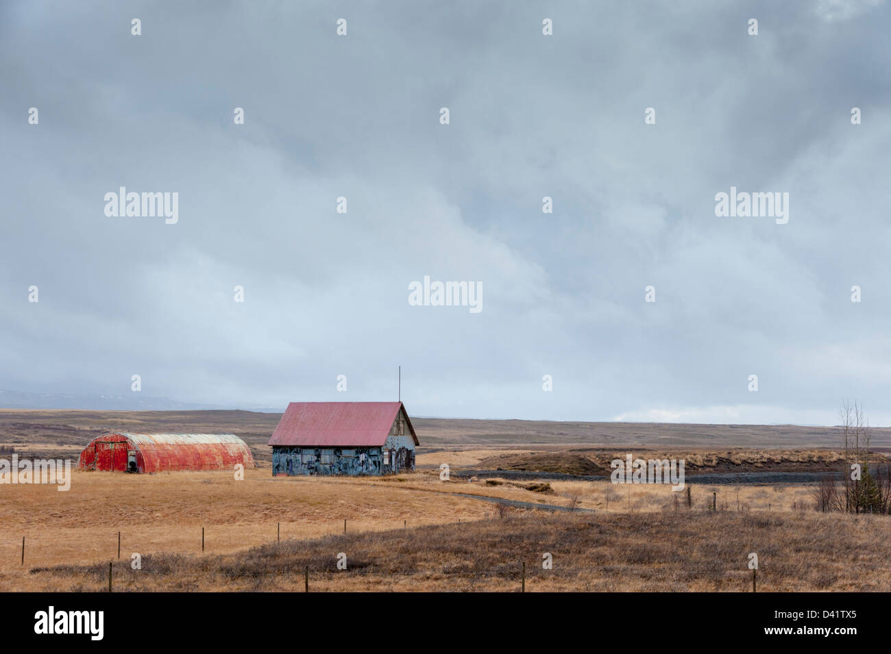Paesaggio con due fienili ondulato nei pressi di Geysir Islanda con dark moody sky Foto Stock