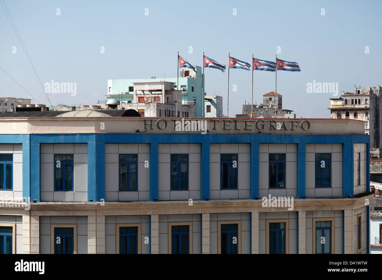 Bandiere cubane battenti sul tetto dell'Hotel Telegrago nel centro di Havana Cuba Foto Stock