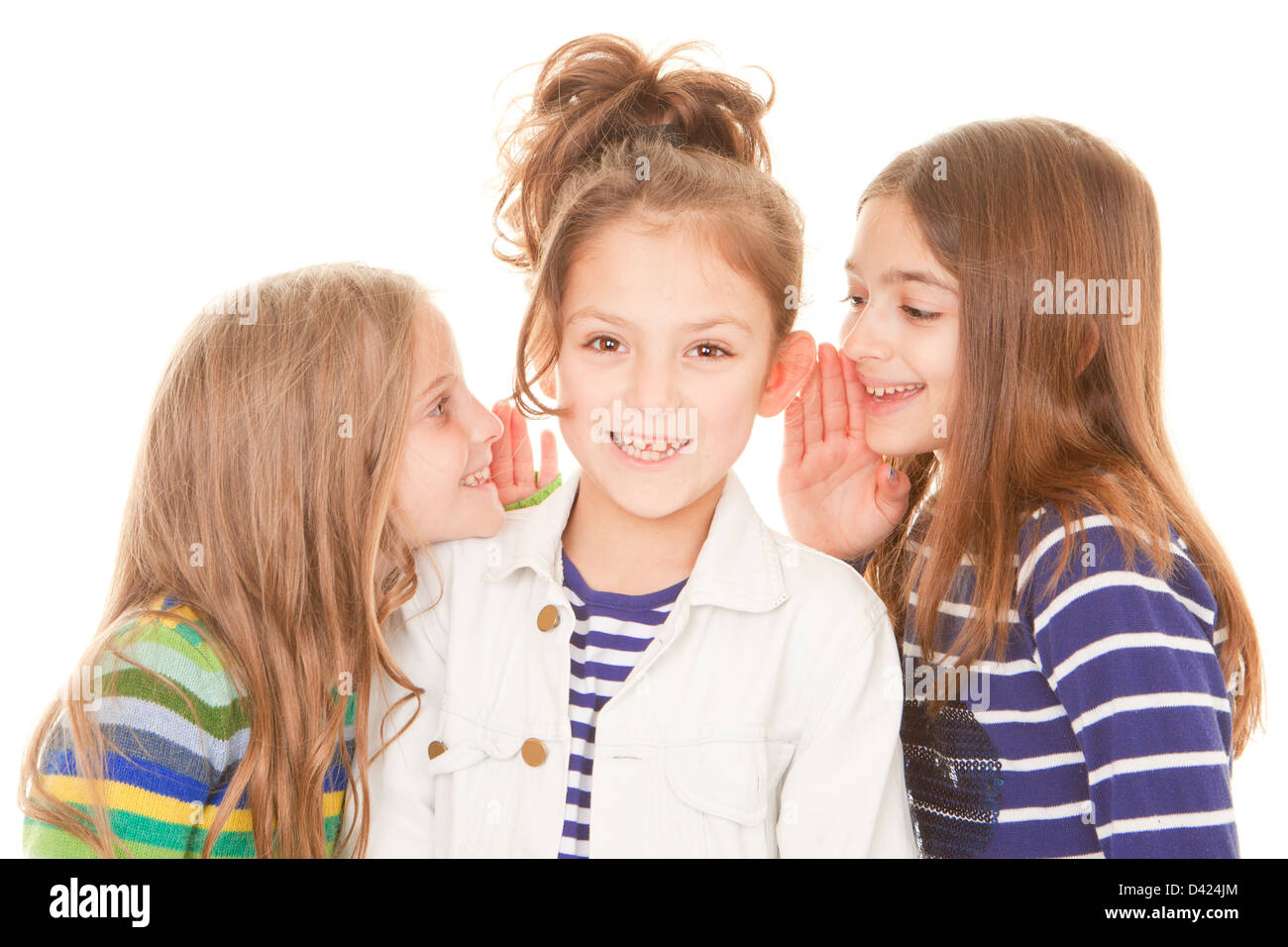 Amici whispering segreti per bambino felice Foto Stock