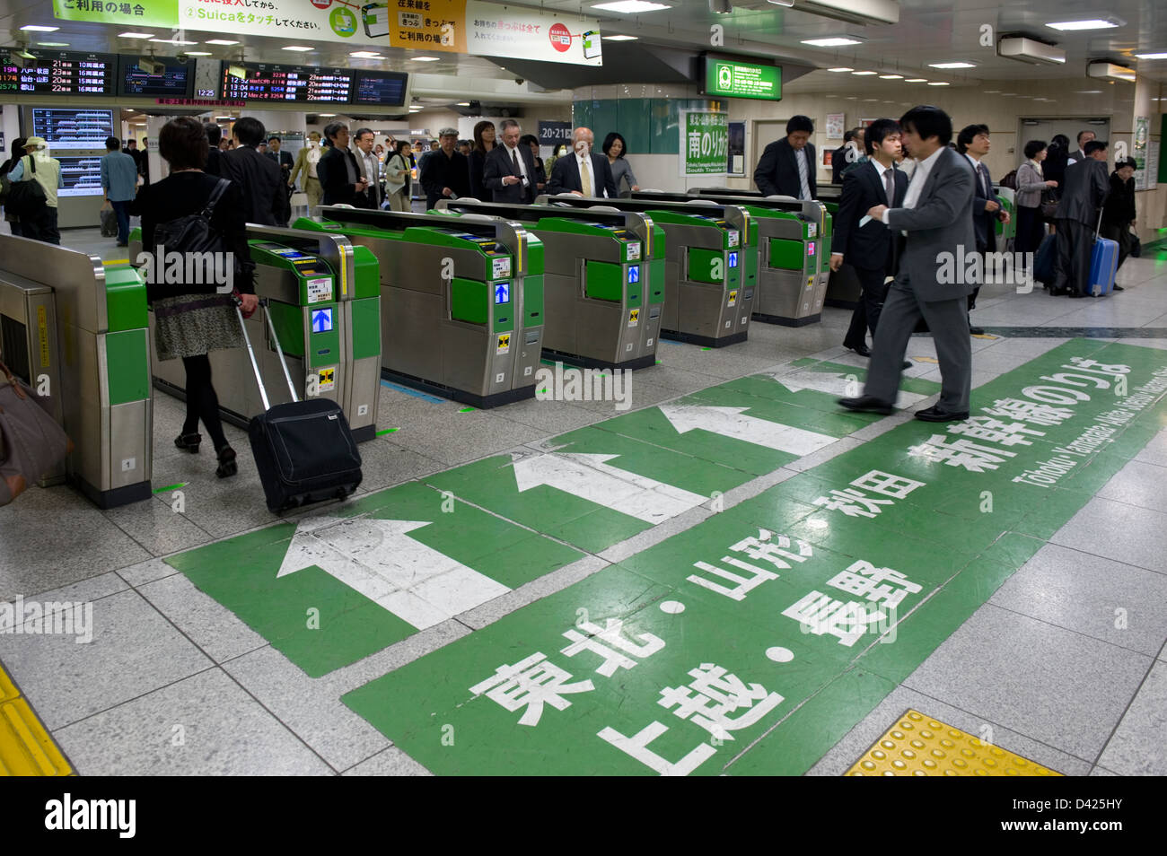 Gli imprenditori e i " commuters " passando attraverso electronic wickets sul loro modo per il treno superveloce shinkansen piattaforme a Stazione di Tokyo Foto Stock