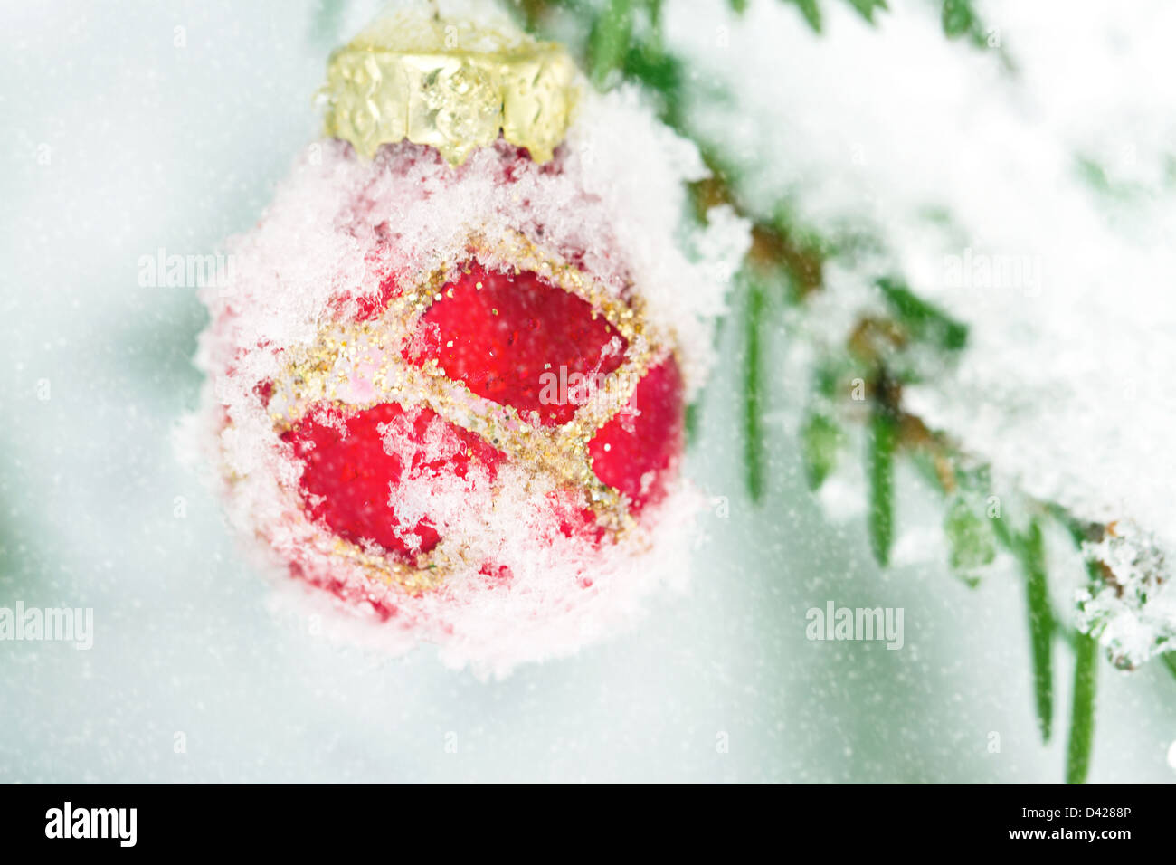 Primo piano della snowy red decorazione di Natale al di fuori nella neve Foto Stock