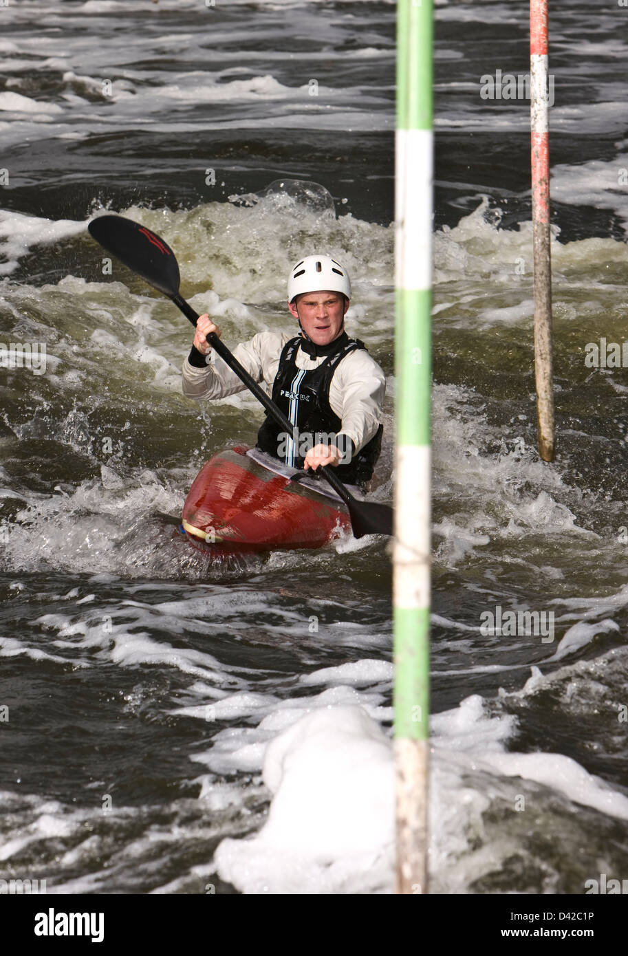 Canoer paddling con determinazione attraverso posti sulle rive di un fiume Foto Stock