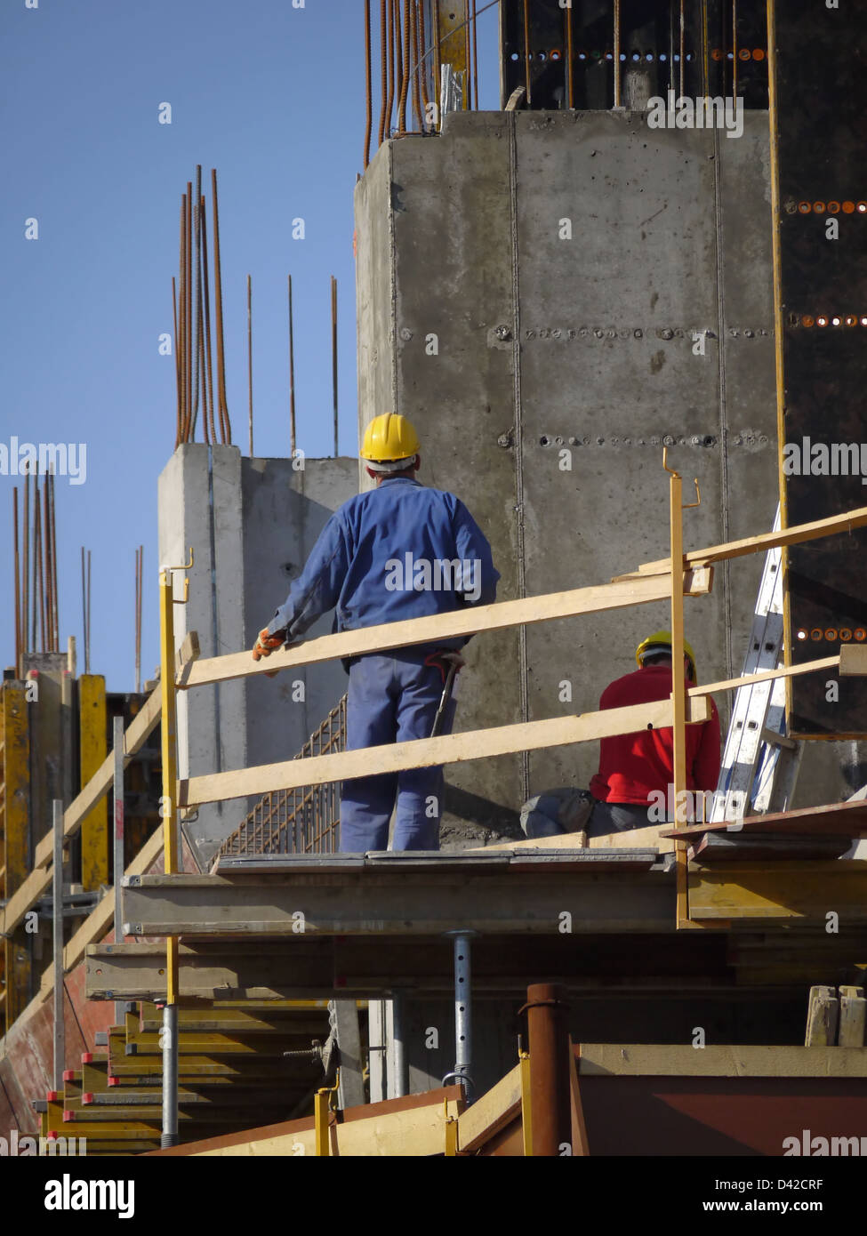 Costruzione i lavoratori che operano sulla piattaforma di costruzione con cassaforma Foto Stock