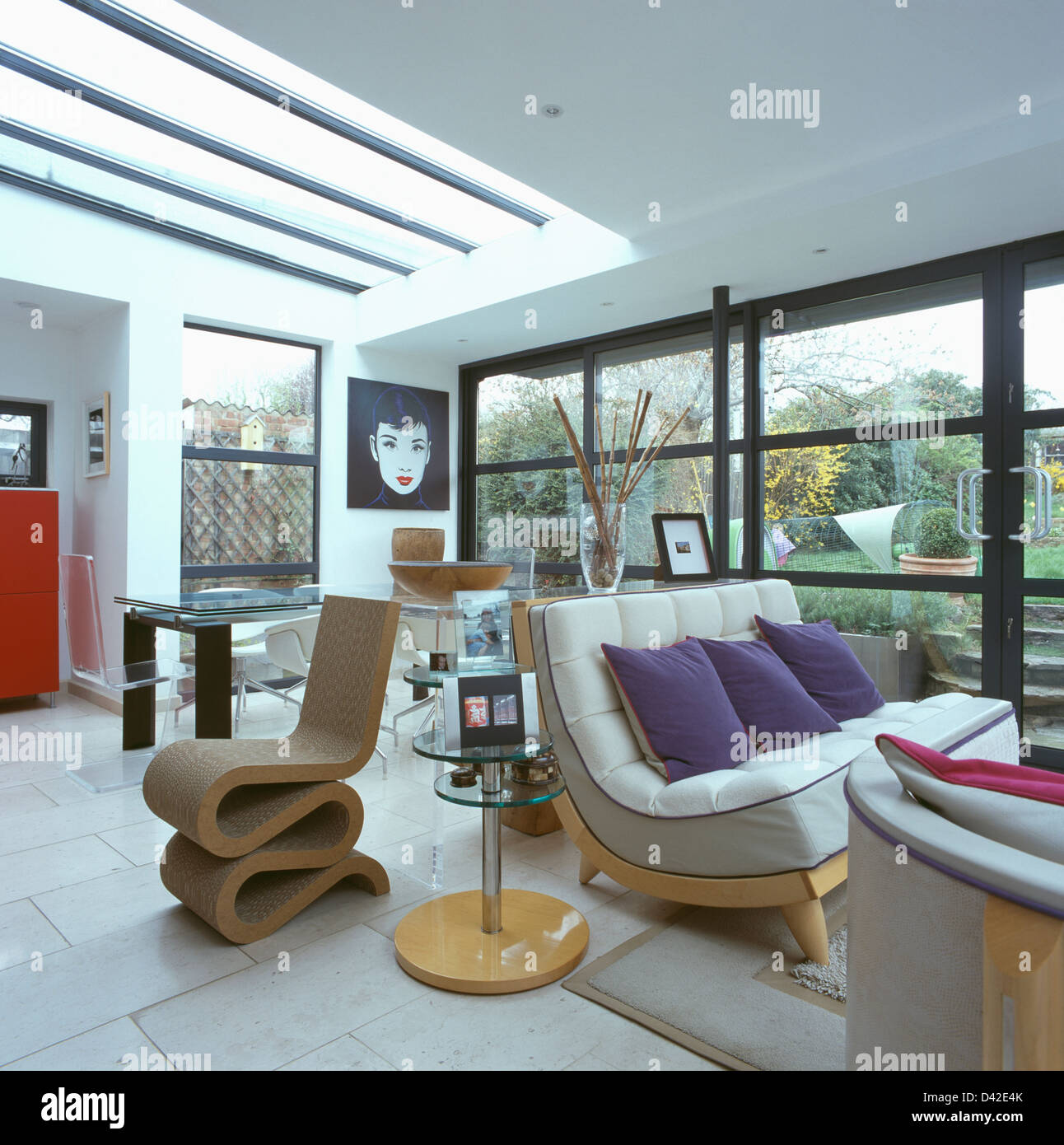 Frank Gehry dei falsi contatti sedia laterale accanto al piccolo tavolo da pranzo in soggiorno a piano aperto e sala da pranzo Foto Stock