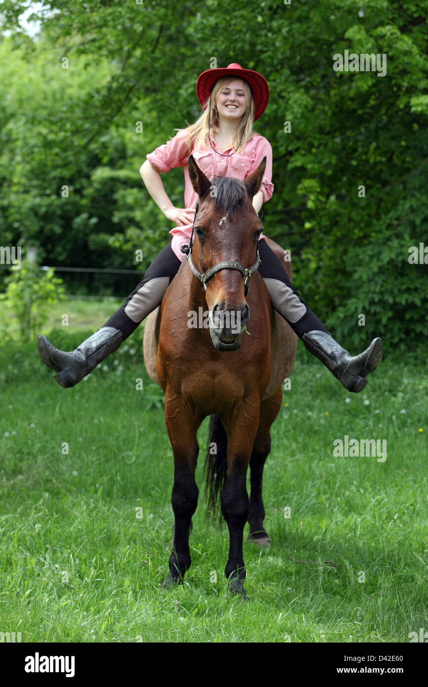 Muehlenbeck, la Germania, la ragazza con il cappello da cowboy seduta sul suo cavallo ridere Foto Stock