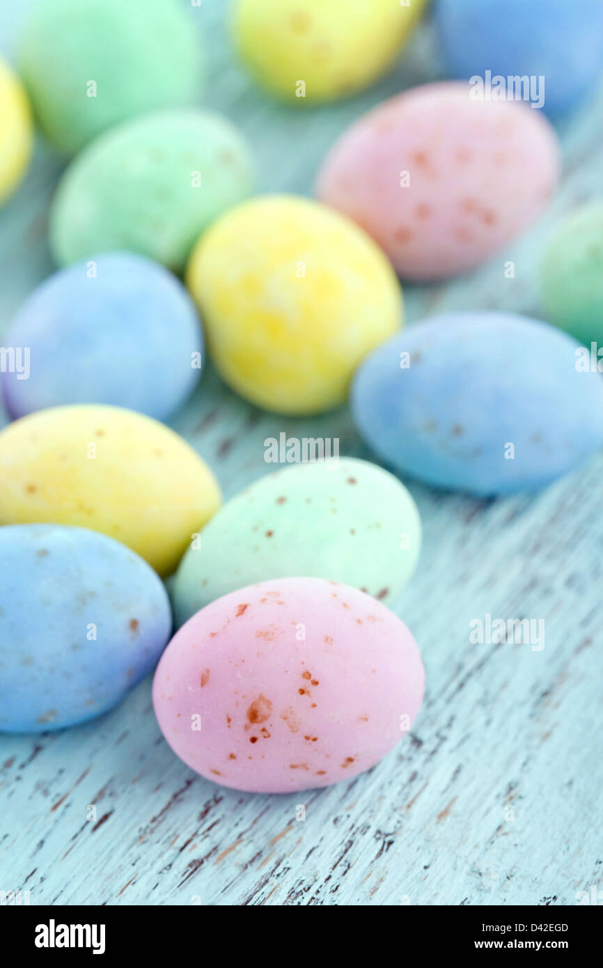Piccolo pastello di cioccolato uova di pasqua su vintage azzurro sfondo di legno Foto Stock