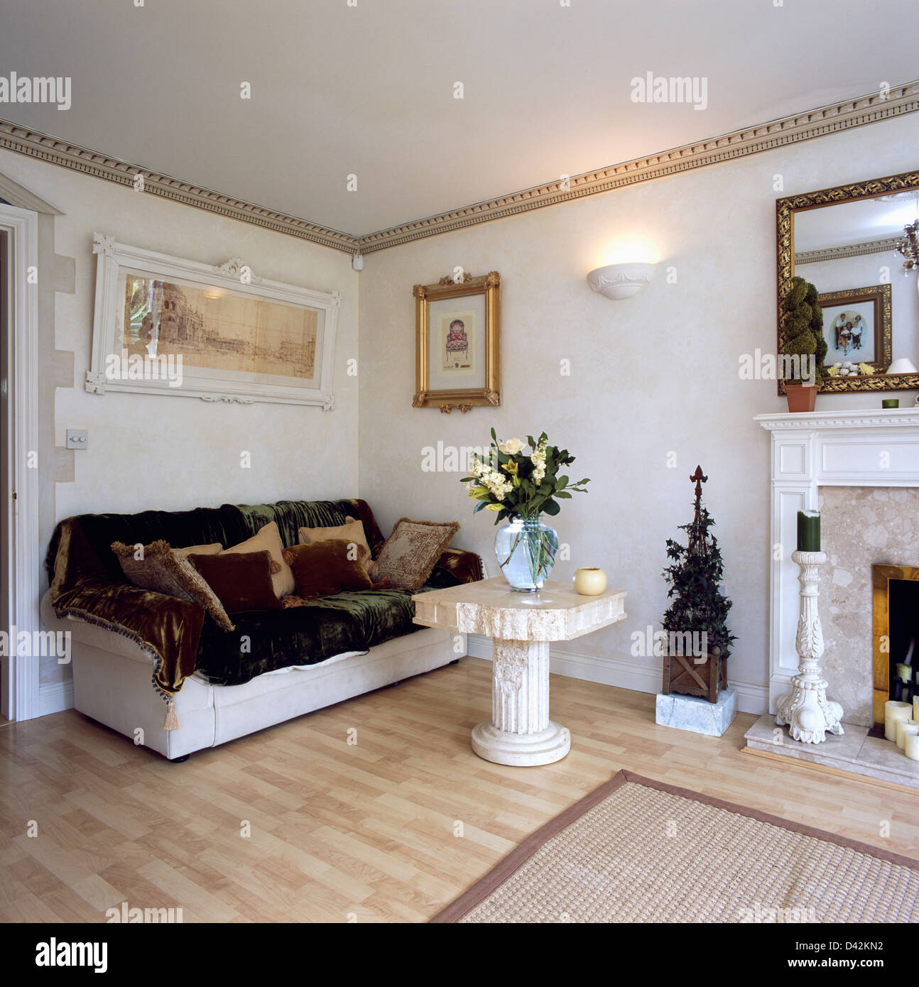 Pellicce artificiali buttare sul divano bianco in bianco soggiorno con piccola pietra tavolo da giardino e pavimenti in laminato Foto Stock