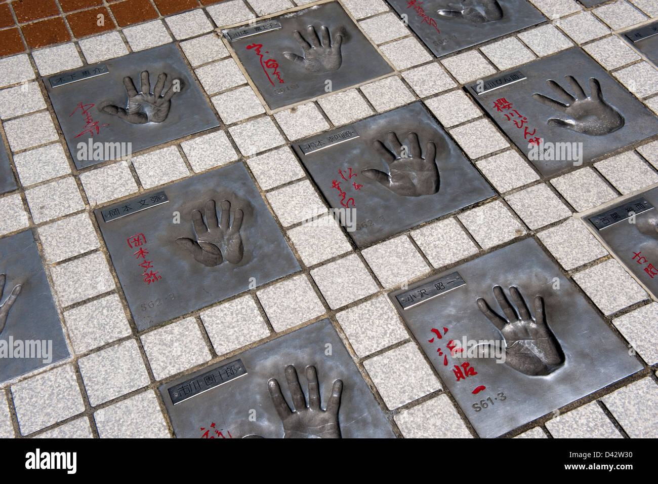 Stampe a mano del famoso film giapponese cast di attori in concreto il marciapiede al di fuori di un teatro nel vecchio quartiere dei divertimenti di Asakusa Foto Stock