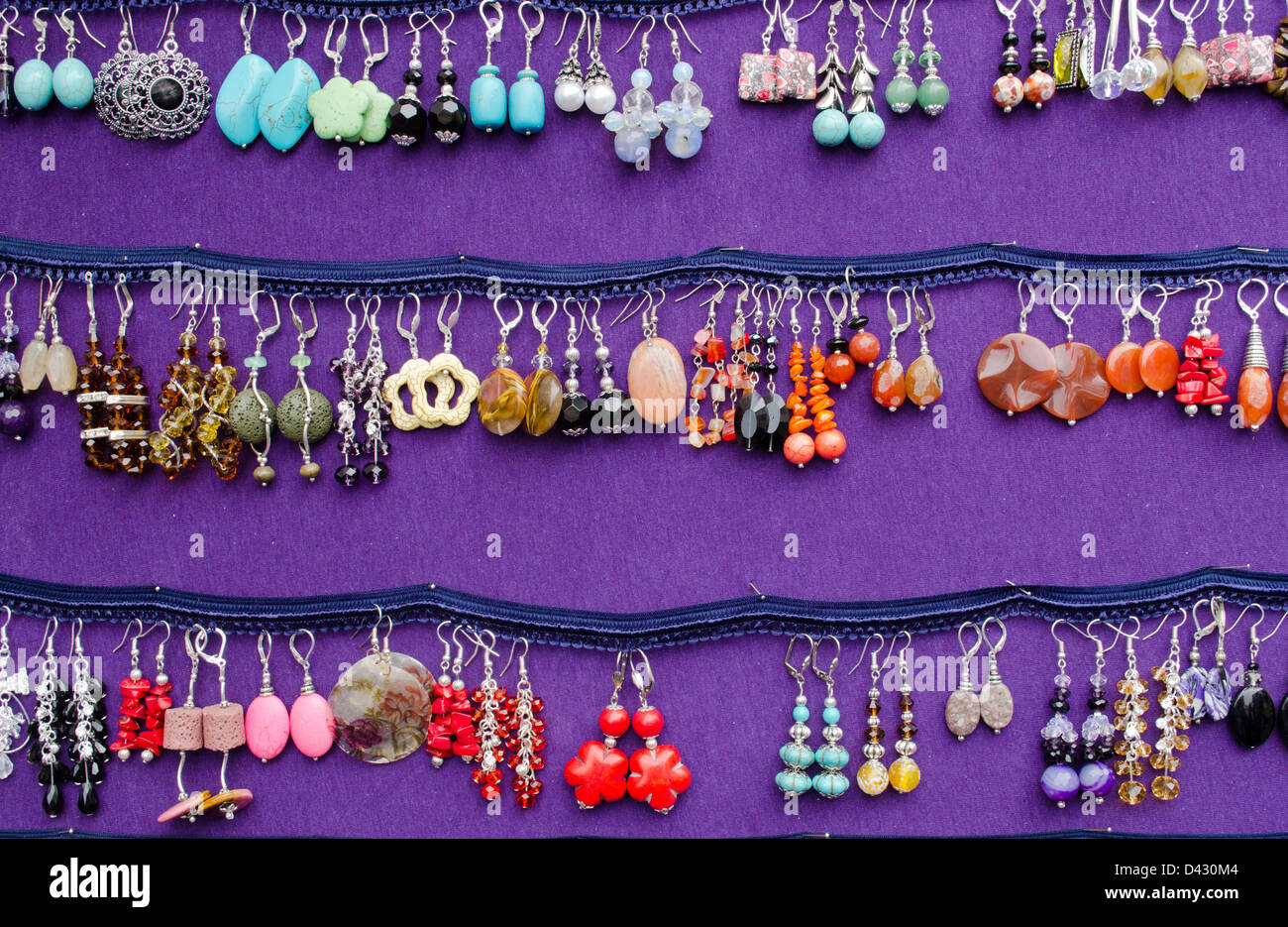 Colorati fatti a mano di varie forma orecchini decorativi gioielli in vendita in outdoor mercato equo. Foto Stock