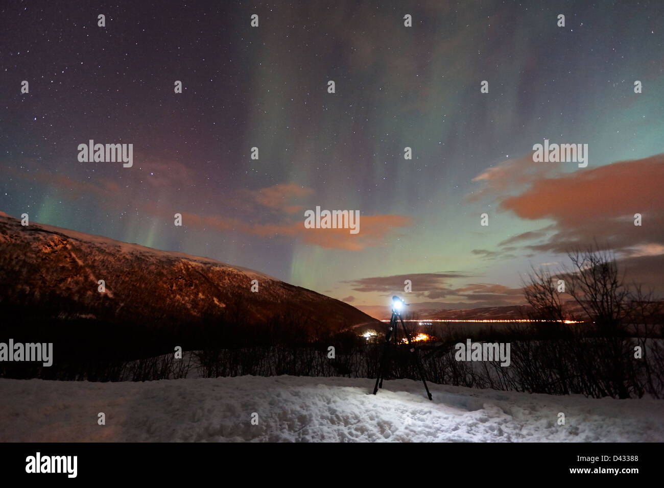 Treppiede e fotocamera impostata fino a fotografare il moto vorticoso Northern lights aurora boreale nei pressi di Tromso in Norvegia del nord europa Foto Stock