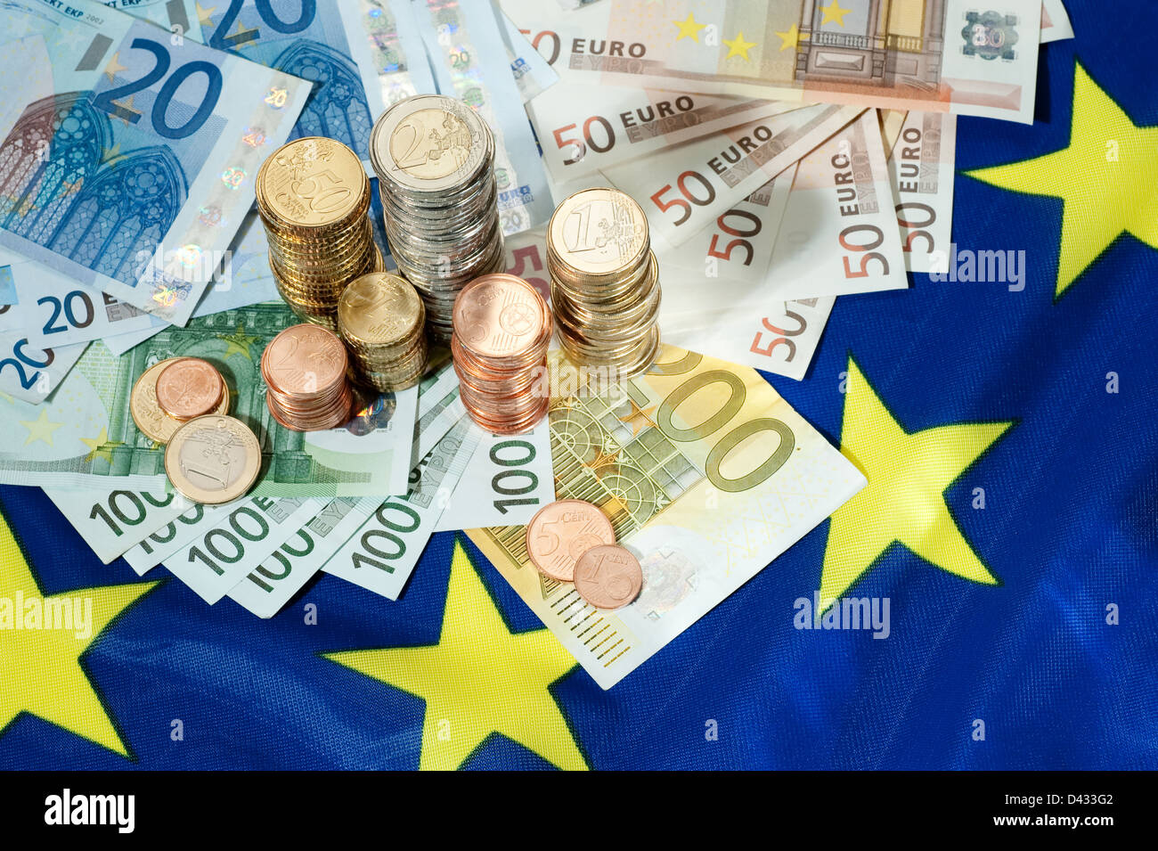 Ad Amburgo in Germania, le banconote in euro e Euromuenzen su una bandiera europea Foto Stock