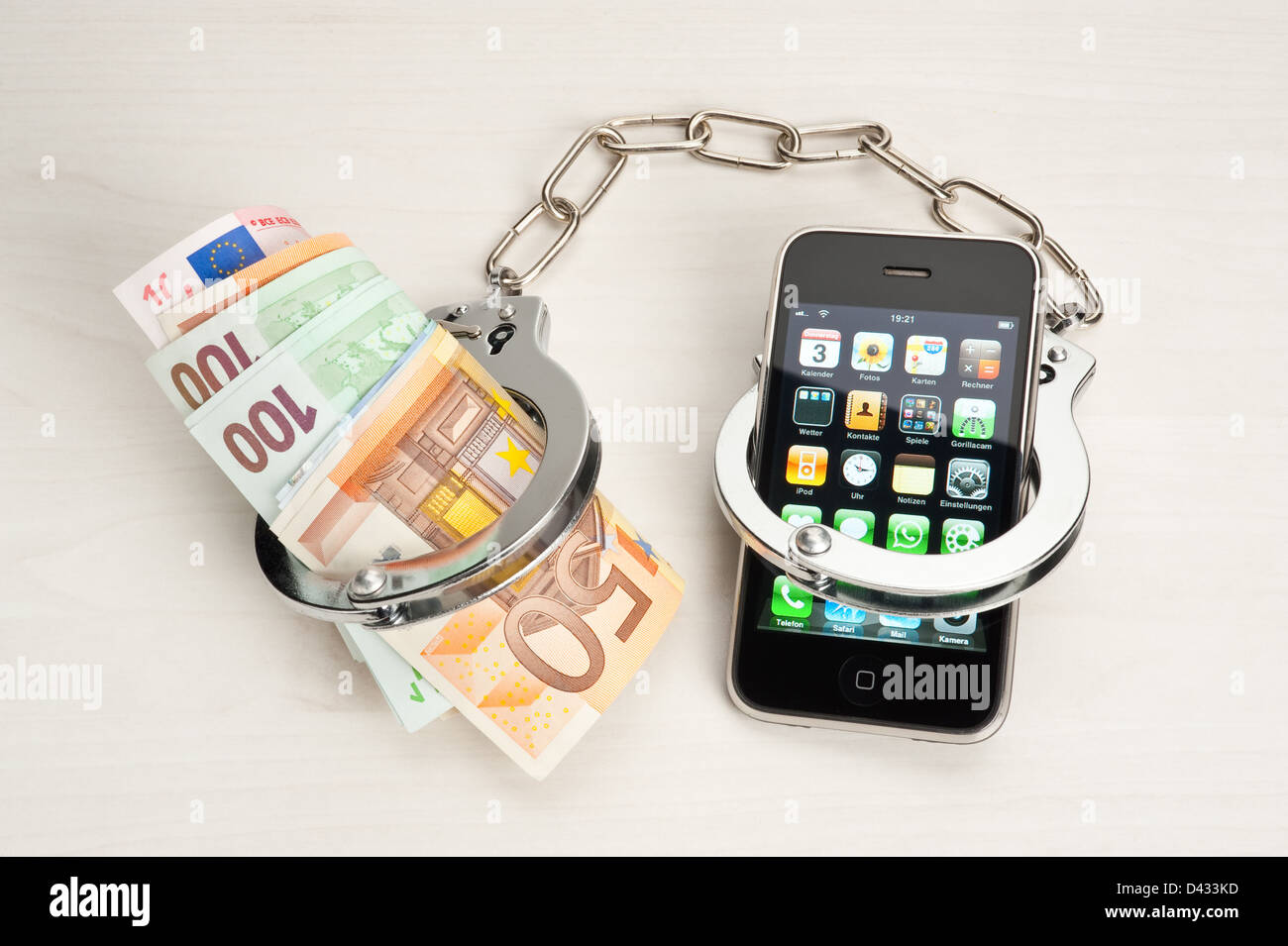 Amburgo, Germania, un iPhone con le banconote in euro e manette Foto stock  - Alamy