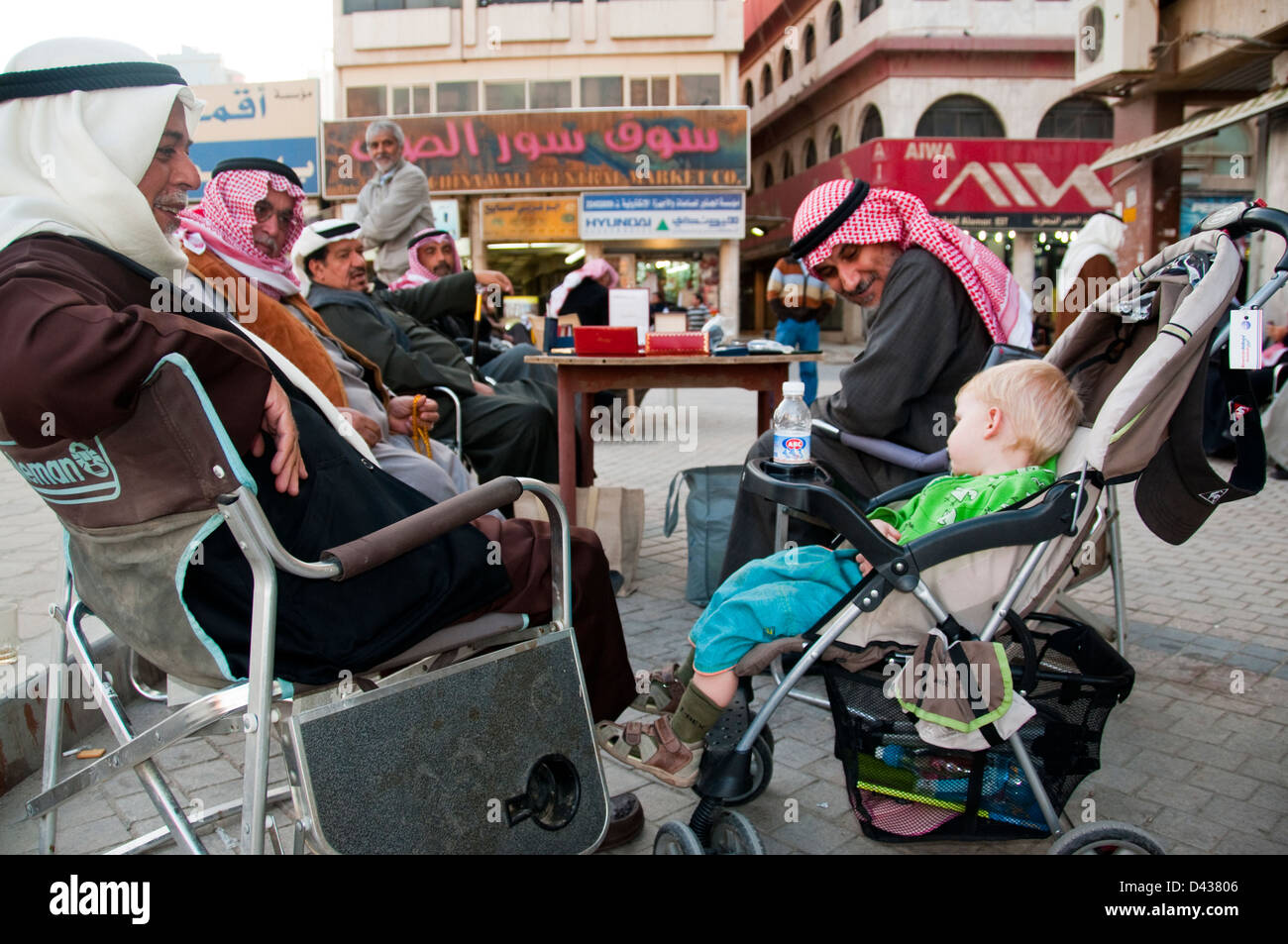 Giovane turista ragazzo addormentato in passeggino attira molti sguardi da gentile locali, Souk Al-Mubarak, Kuwait Foto Stock