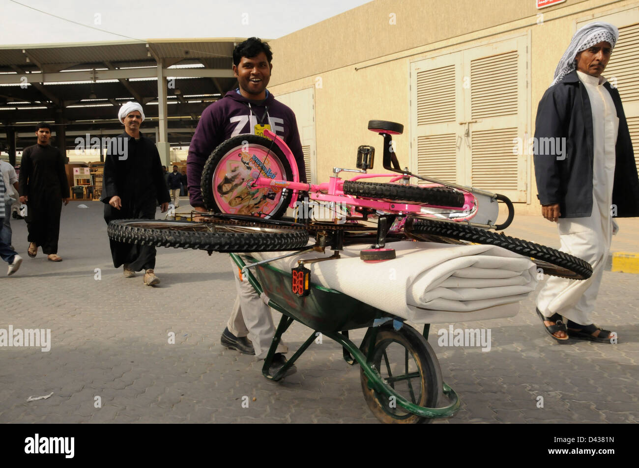 Uomo con le biciclette sulla carriola, Souq al Jum'a (mercato del venerdì) Kuwait City Foto Stock