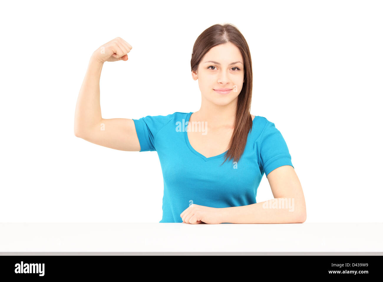 Una giovane donna sorridente mostrando il suo muscolo bicipite isolato su sfondo bianco Foto Stock