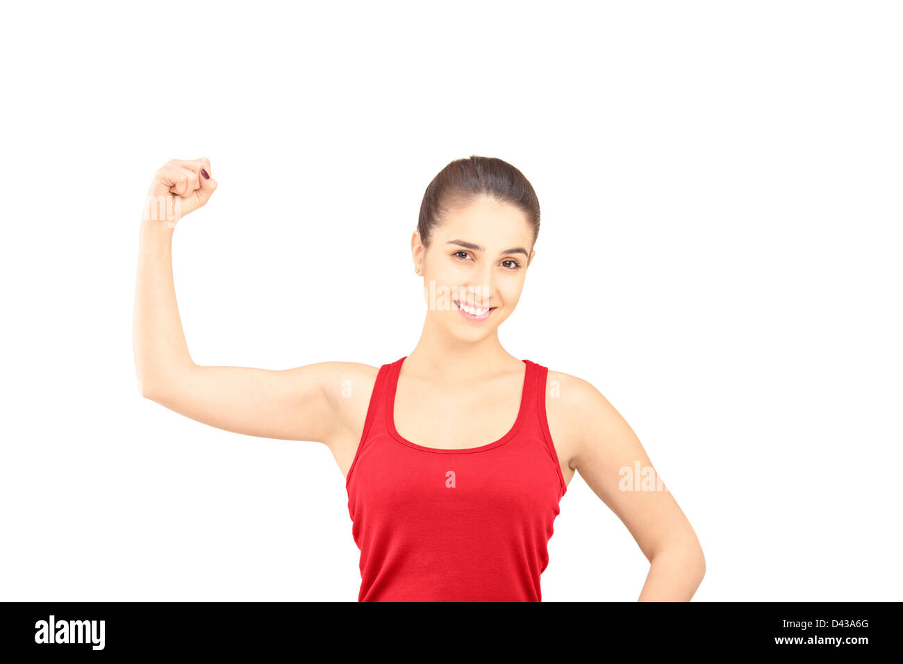 Giovane donna sorridente mostrando il suo muscolo bicipite isolato su sfondo bianco Foto Stock