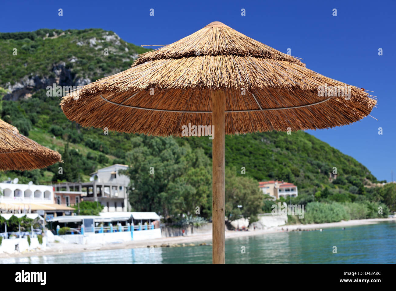 Ombrellone su una spiaggia del Mediterraneo. L'isola di Corfù, Grecia Foto Stock