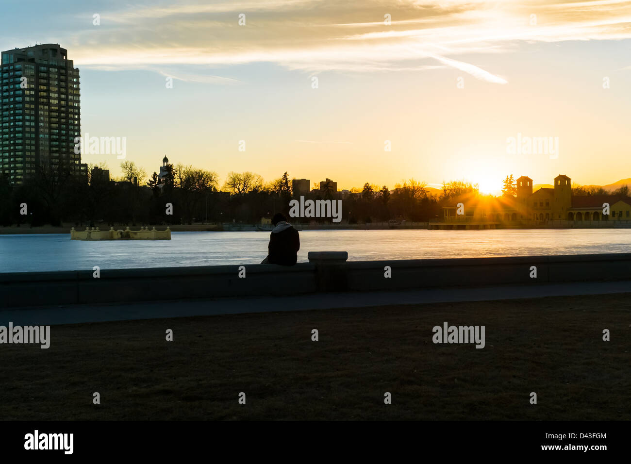 Una immagine concettuale di una persona a guardare il tramonto al Lago Ferril a Denver parco della città. Foto Stock