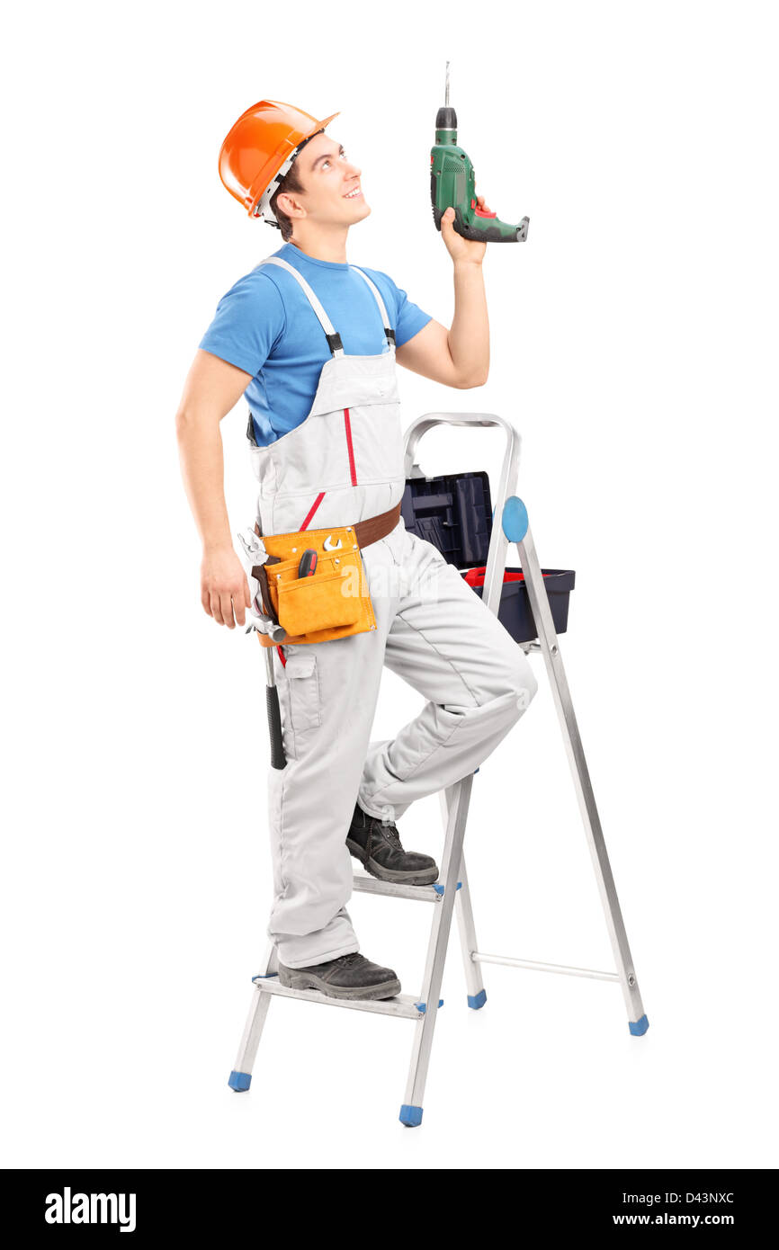 Un giovane lavoratore su una scaletta tenendo un trapanatore isolati su sfondo bianco Foto Stock