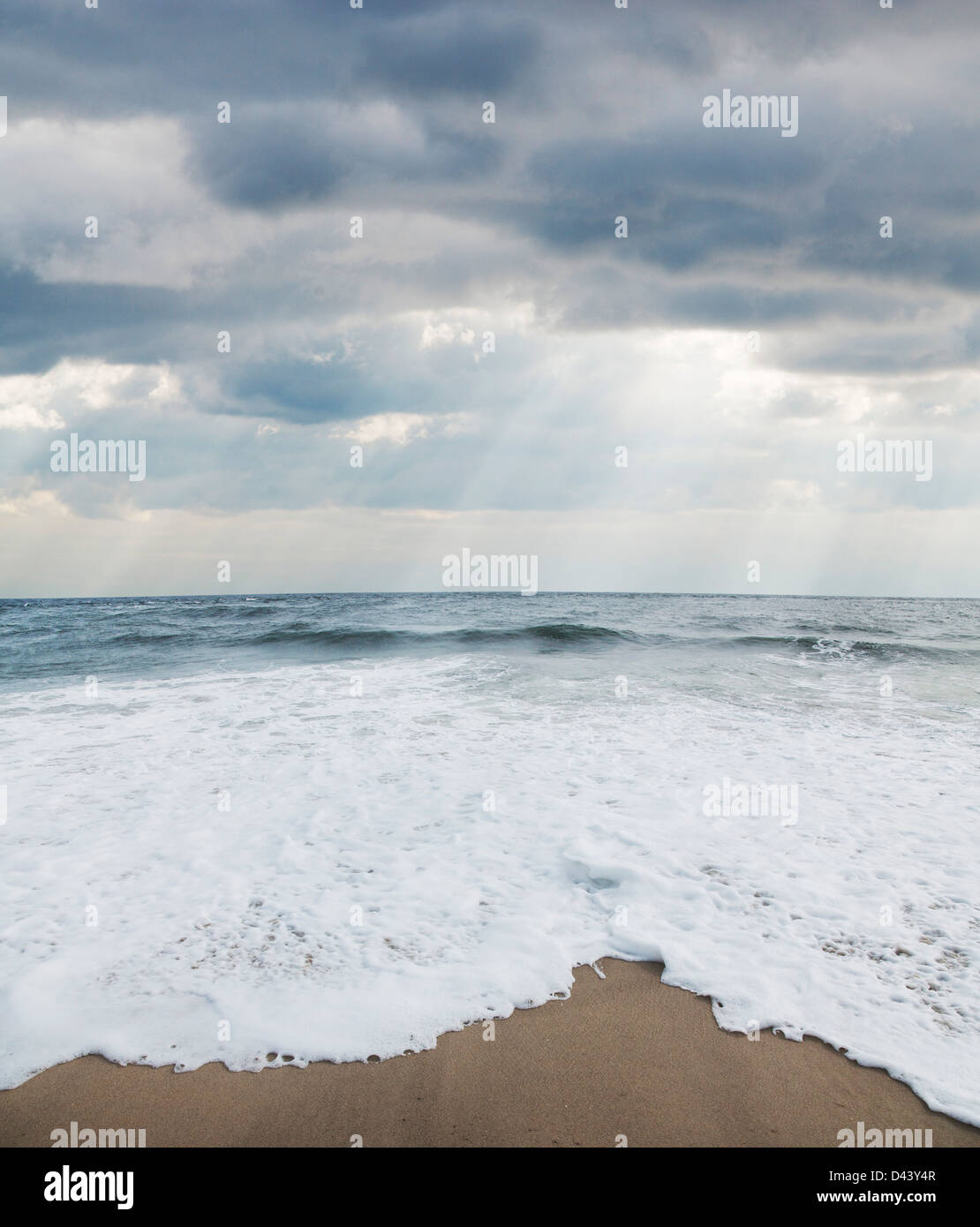 Le onde a spiaggia con Sunray attraverso le nuvole, punto piacevole, New Jersey, STATI UNITI D'AMERICA Foto Stock