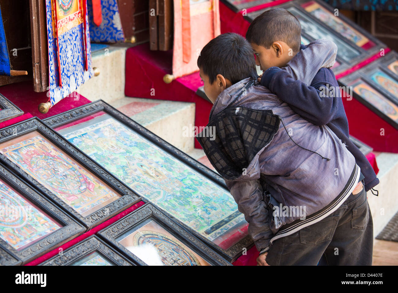Ragazzi guardando mandala buddista a Stupa Boudhanath, Kathmandu, Nepal Foto Stock
