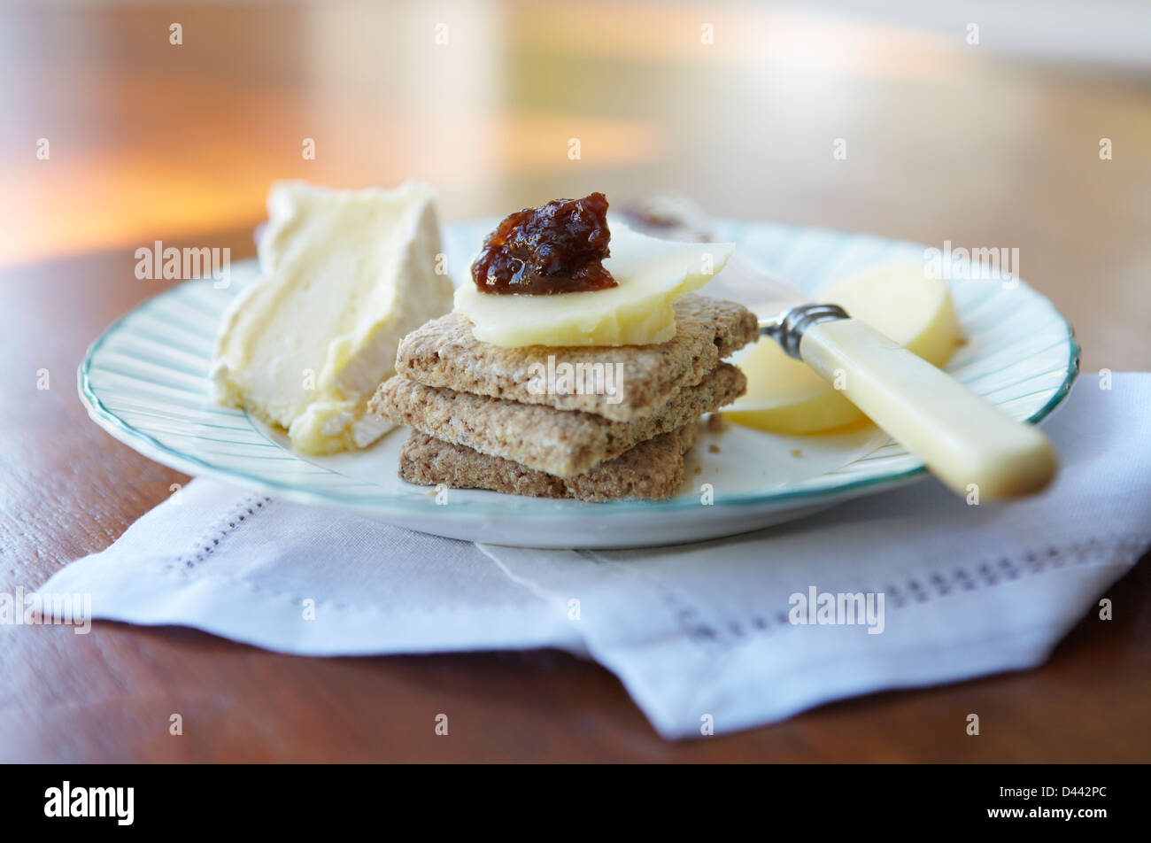 Formaggi e biscotti su una piastra vintage e tovagliolo di lino su di un tavolo di legno. Foto Stock