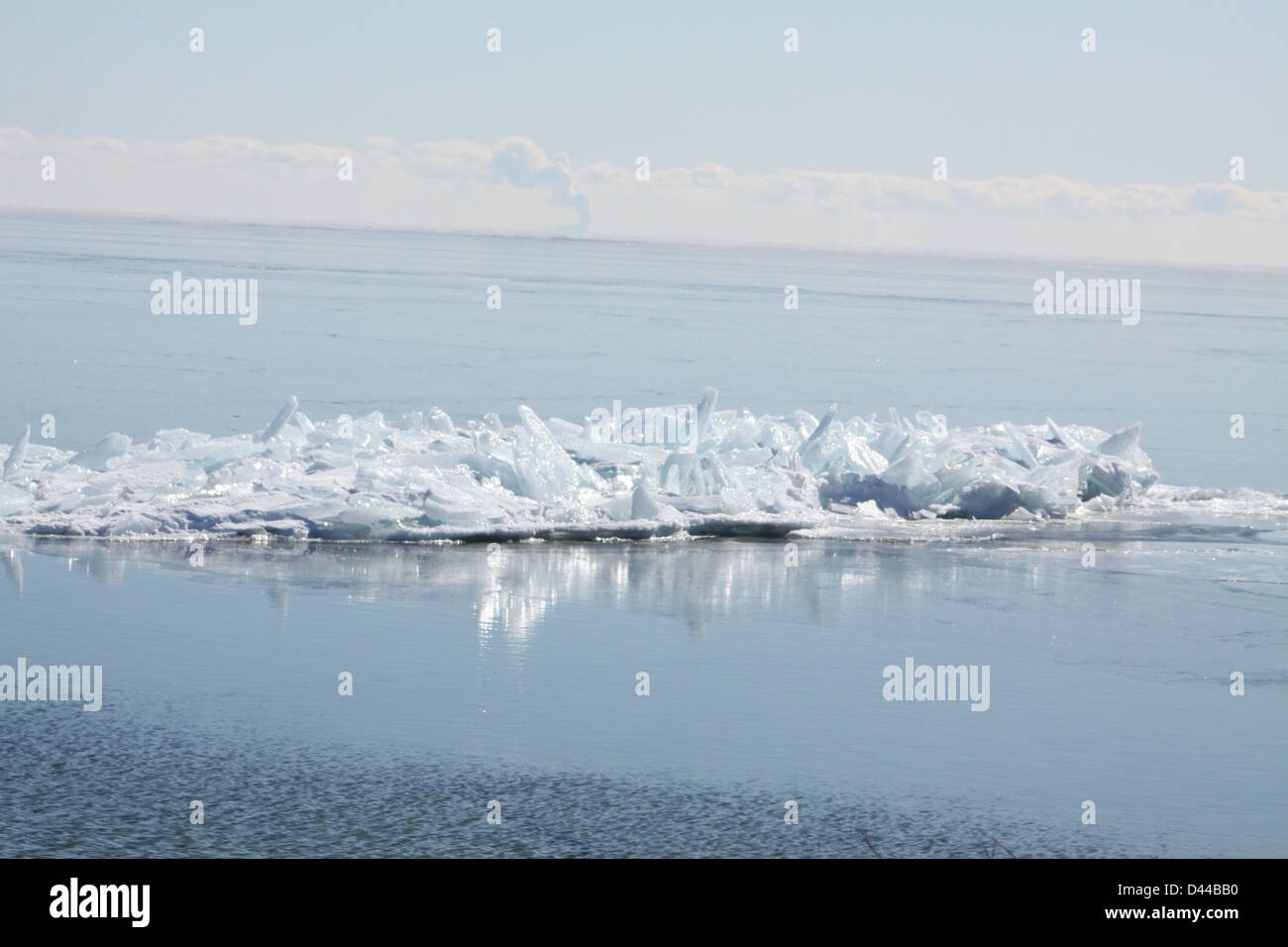 Massa di pezzi di ghiaccio formando una pila su un banco di sabbia in fondali bassi di un grande lago. Foto Stock