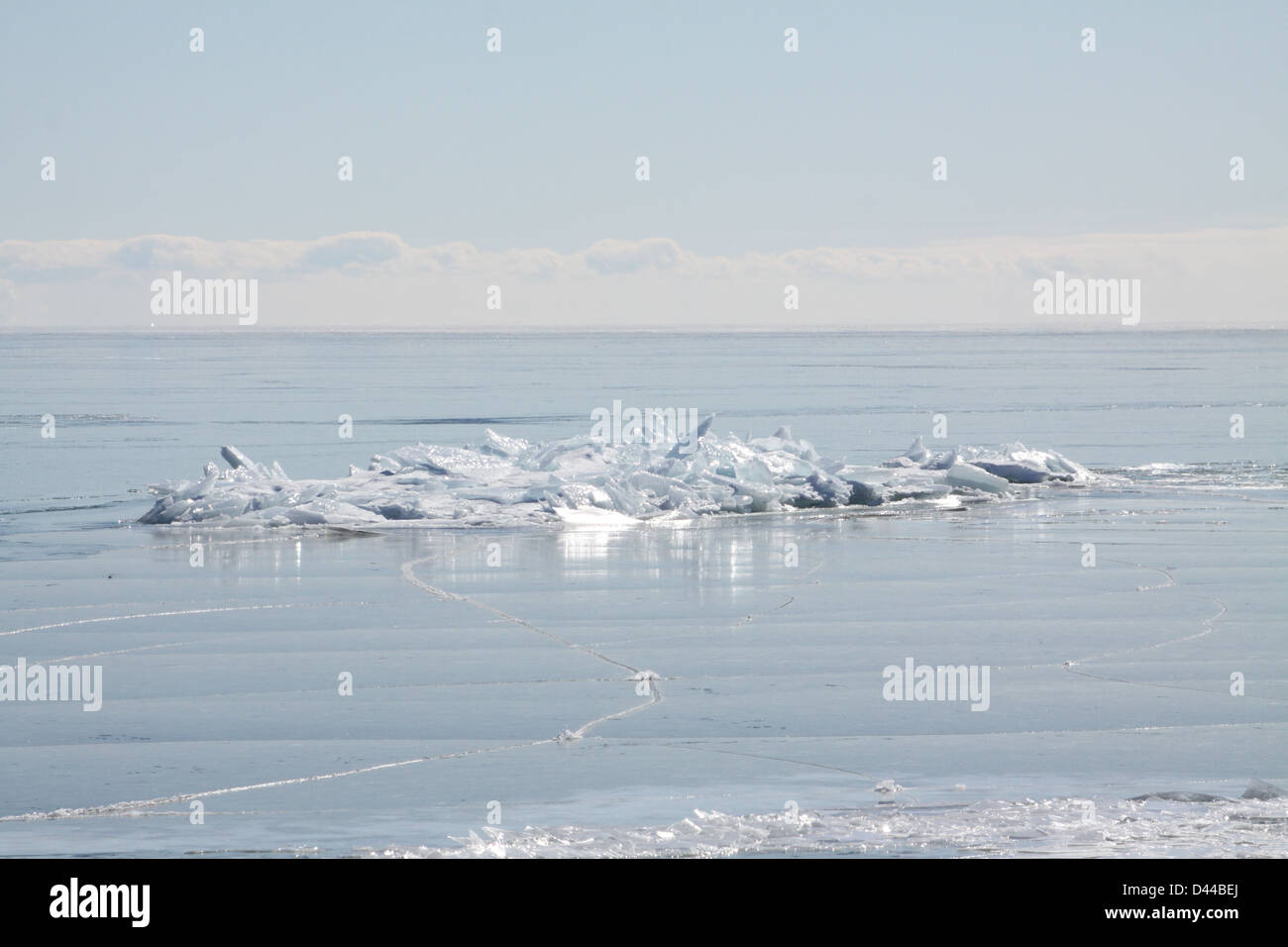 Massa di pezzi di ghiaccio formando una pila su un banco di sabbia in fondali bassi di un grande lago. Foto Stock