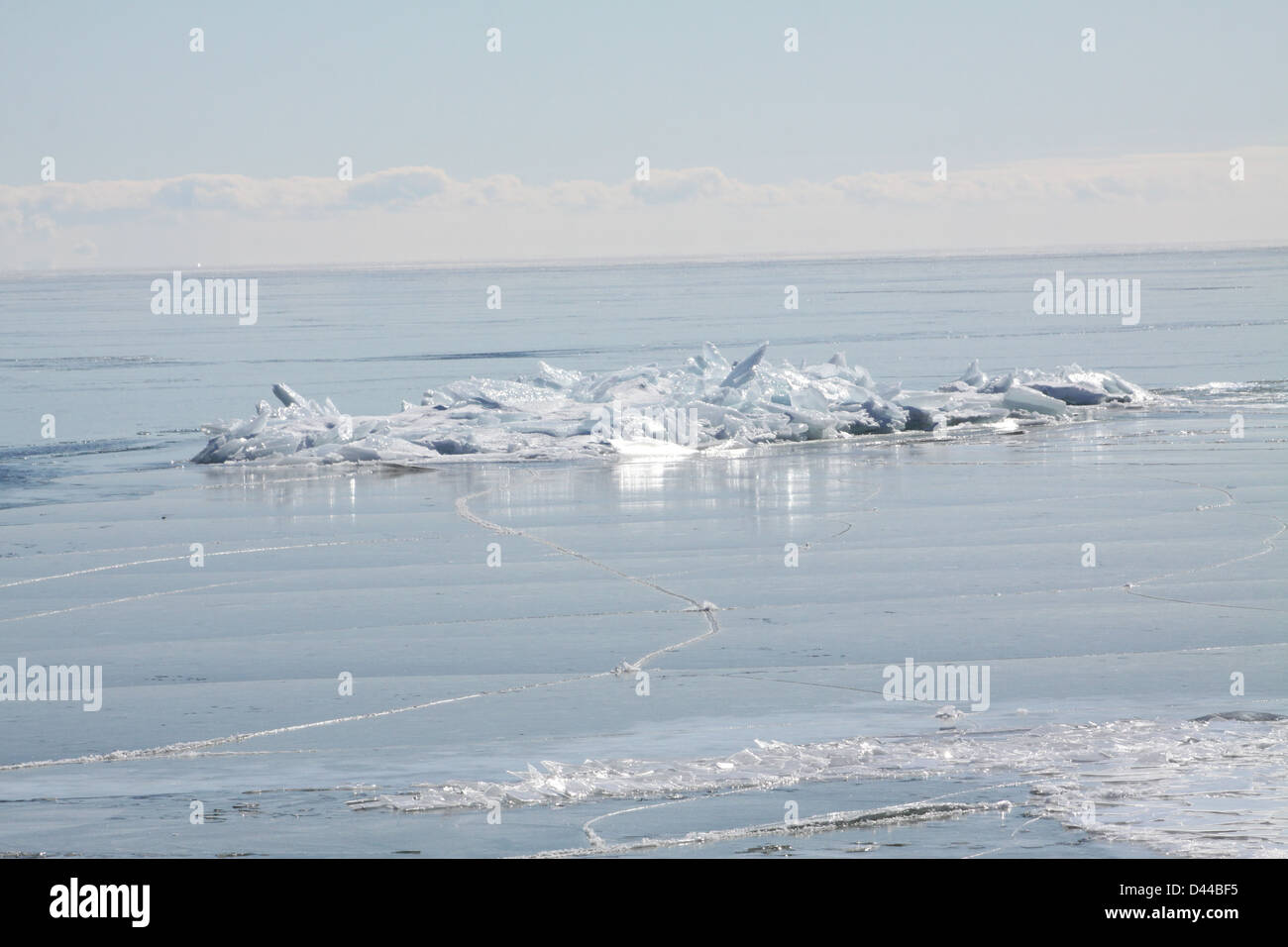 Massa di pezzi di ghiaccio formando una pila su un banco di sabbia in fondali bassi di un grande lago. Foto Stock