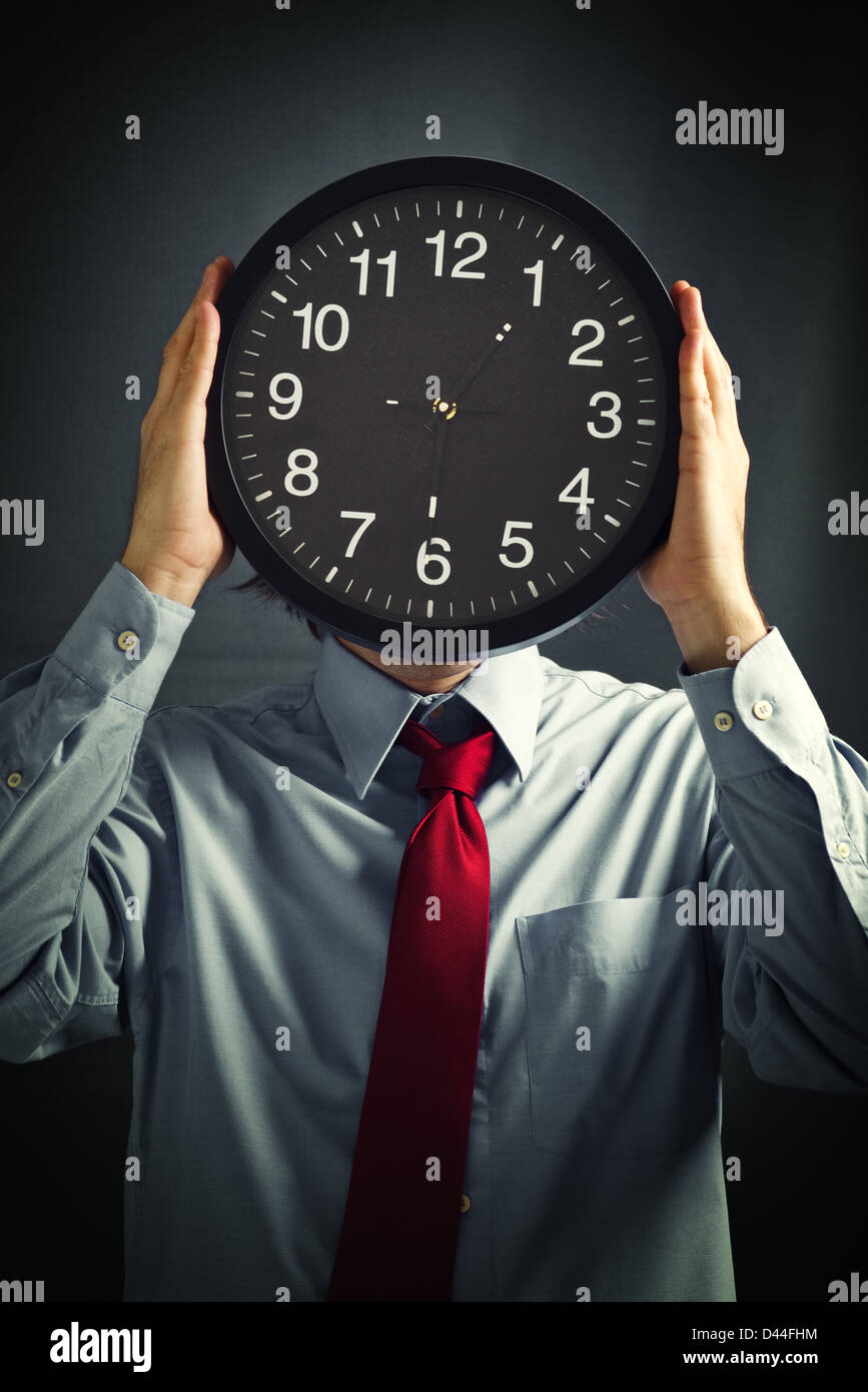 Imprenditore con orologio nero nella parte anteriore della sua testa, termine ultimo concetto. Non ho abbastanza tempo per completare il lavoro. Foto Stock