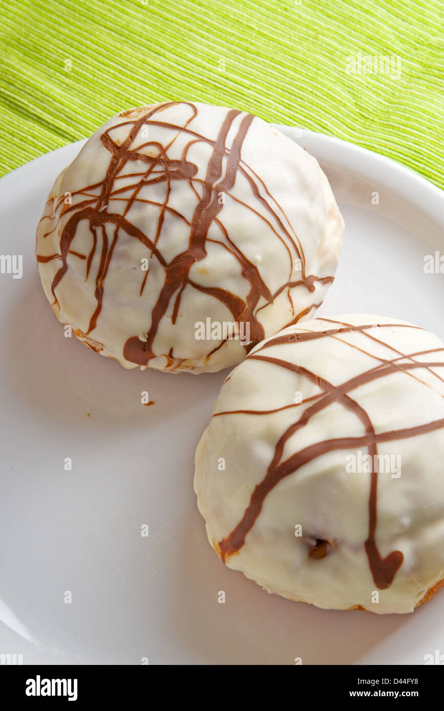 Gustose ciambelle al cioccolato sulla piastra bianca su un tavolo da cucina. Dolce cibo malsano. Foto Stock