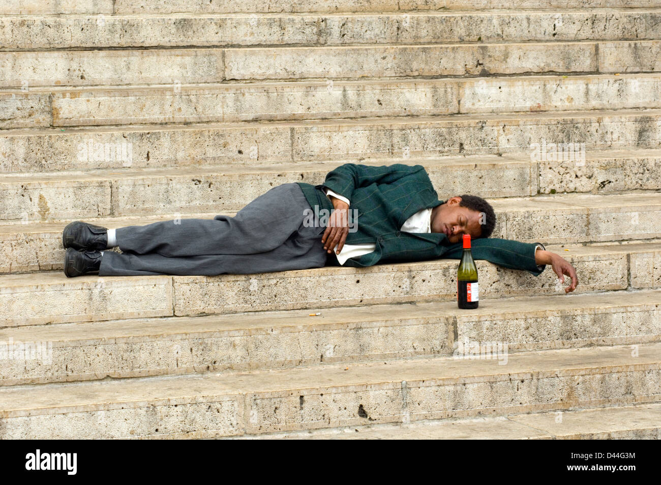 Uomo ubriaco dormendo sui gradini della chiesa Foto Stock