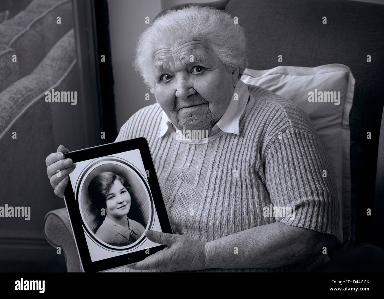 Età di geni di invecchiamento confronto 98 anni di età anziana signora azienda computer tablet iPad, visualizzazione di seppia ritratto di se stessa preso 80 anni fa all età di 18 anni Foto Stock