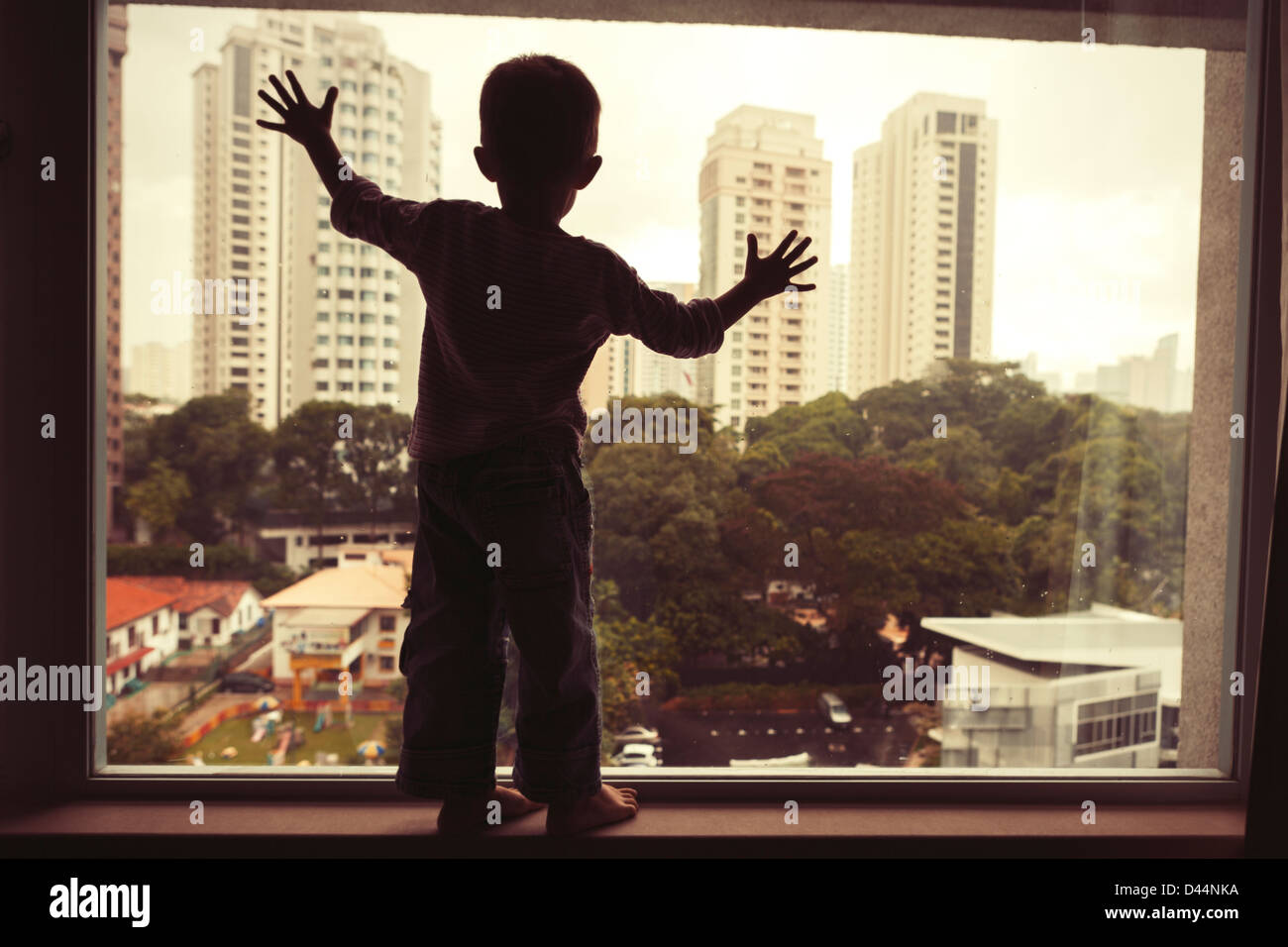 Godendo della vista: boy, finestra, Singapore. Foto Stock